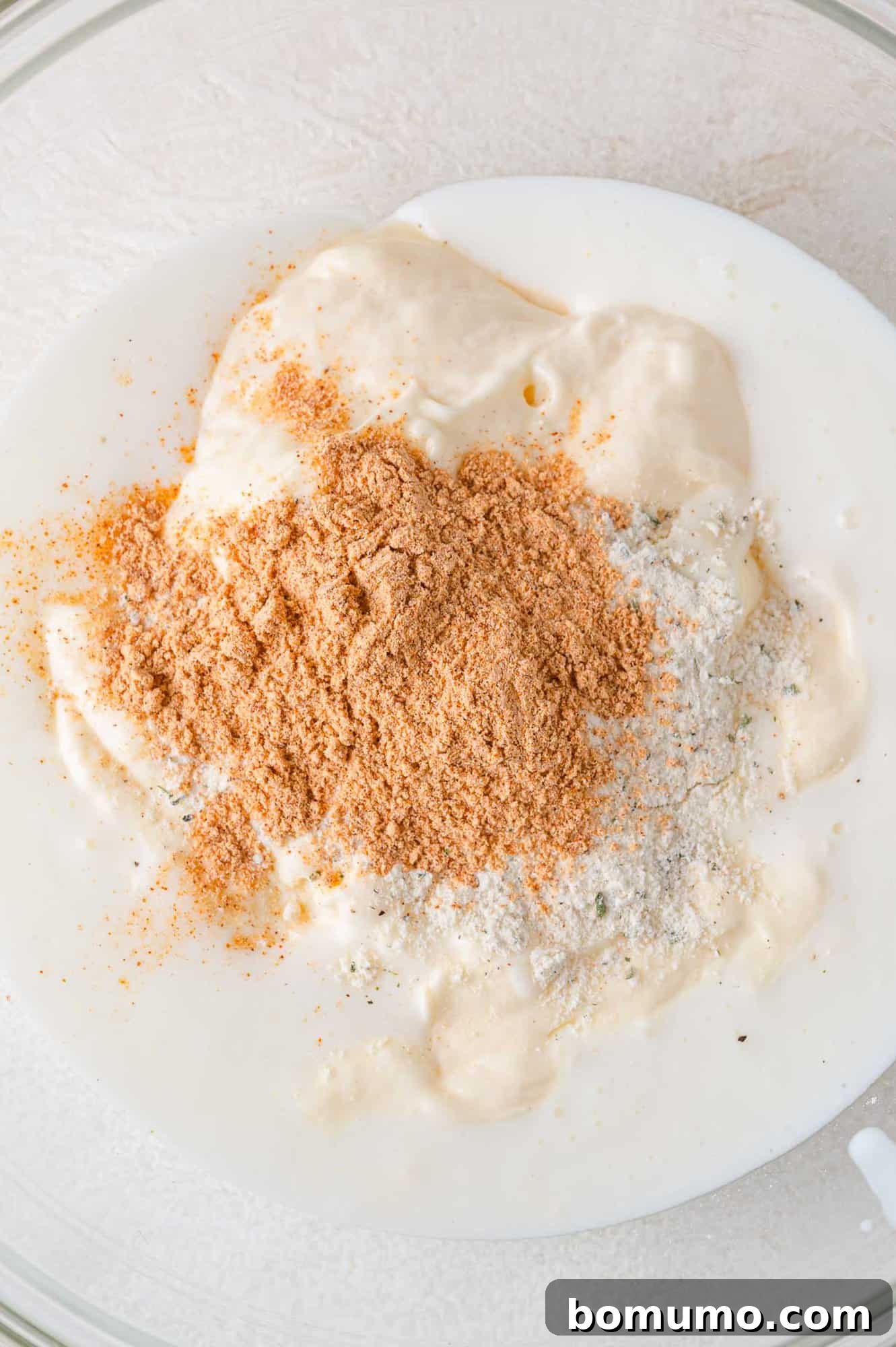Individual dressing ingredients – mayonnaise, buttermilk, ranch mix, and taco seasoning – waiting to be combined.