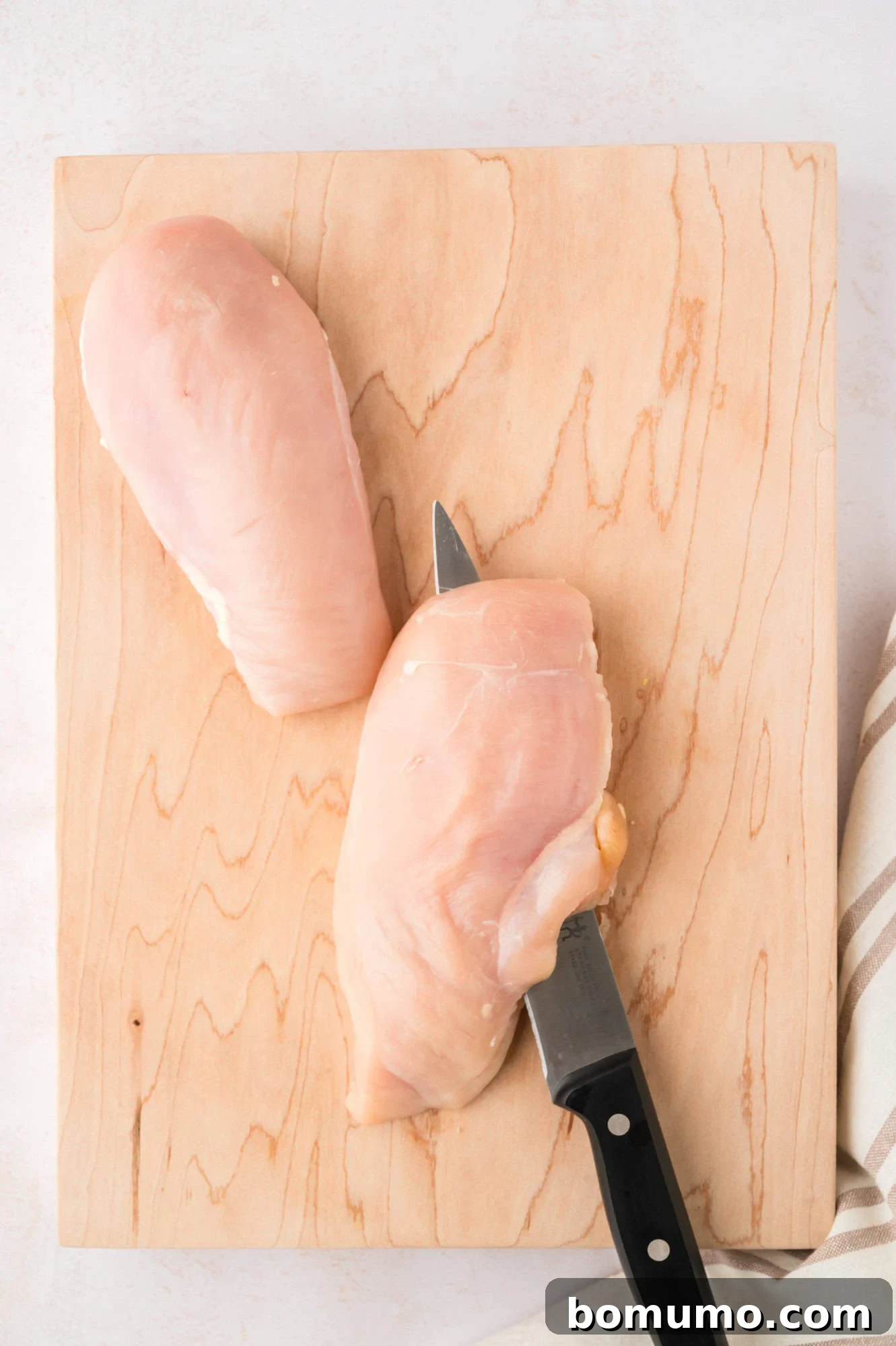 Step one of butterflying - cutting a chicken breast in half.
