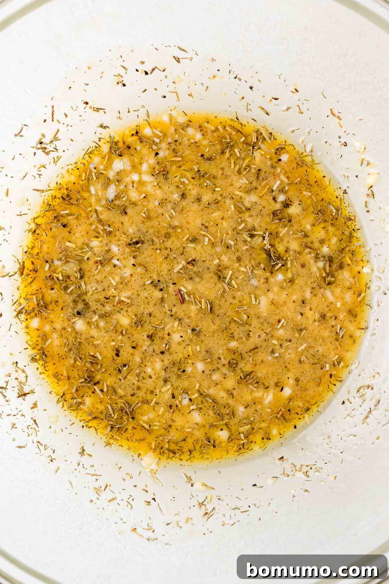 A close-up view of the prepared marinade, showing its creamy texture and herb flecks after mixing.