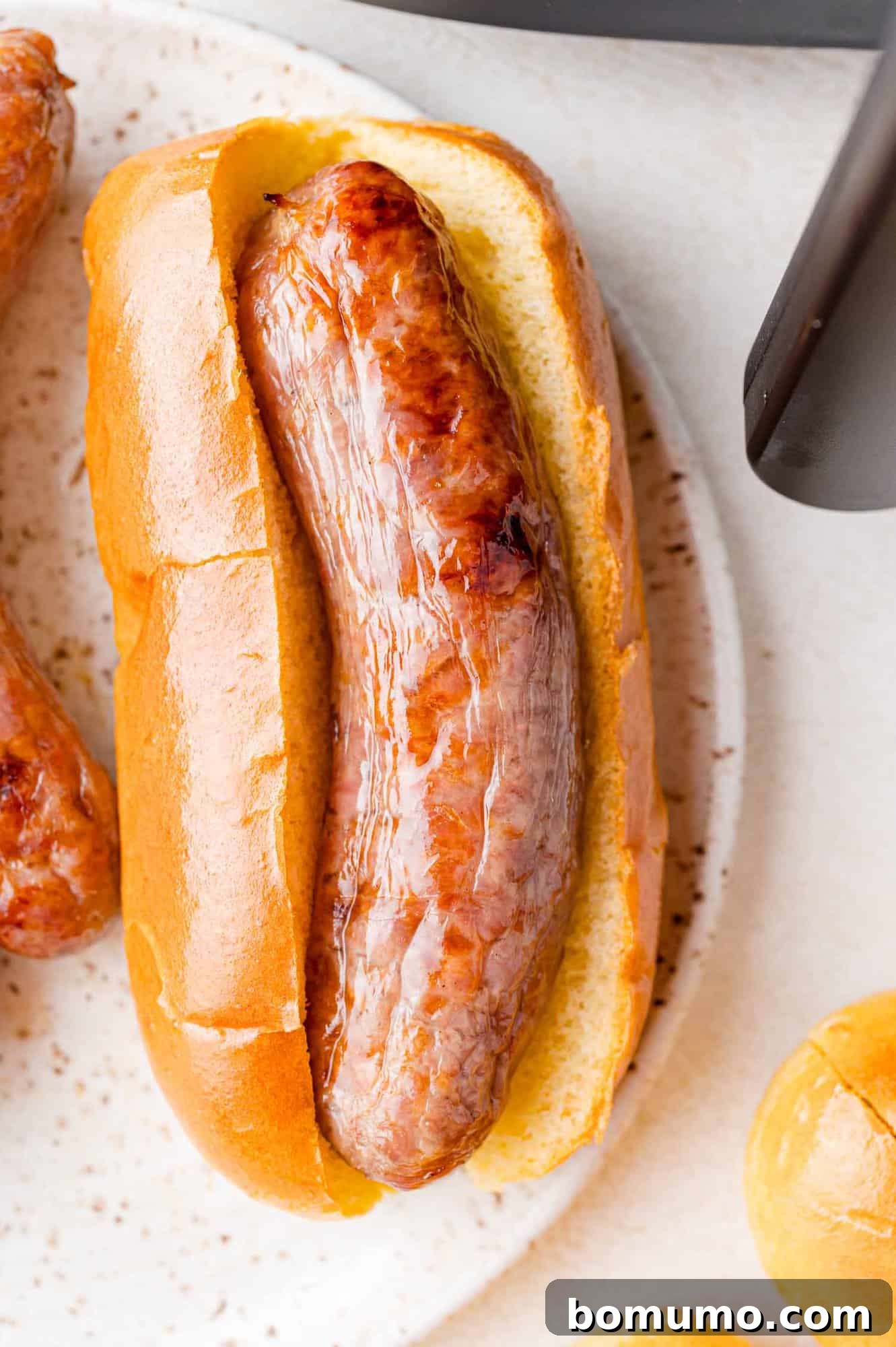Cooked, browned bratwurst on a hot dog bun.
