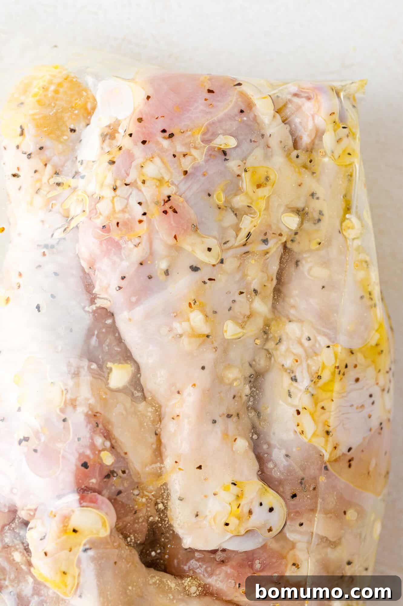 Chicken drumsticks swimming in the flavorful lemon pepper marinade, securely sealed in a zip-top bag and ready for refrigeration.