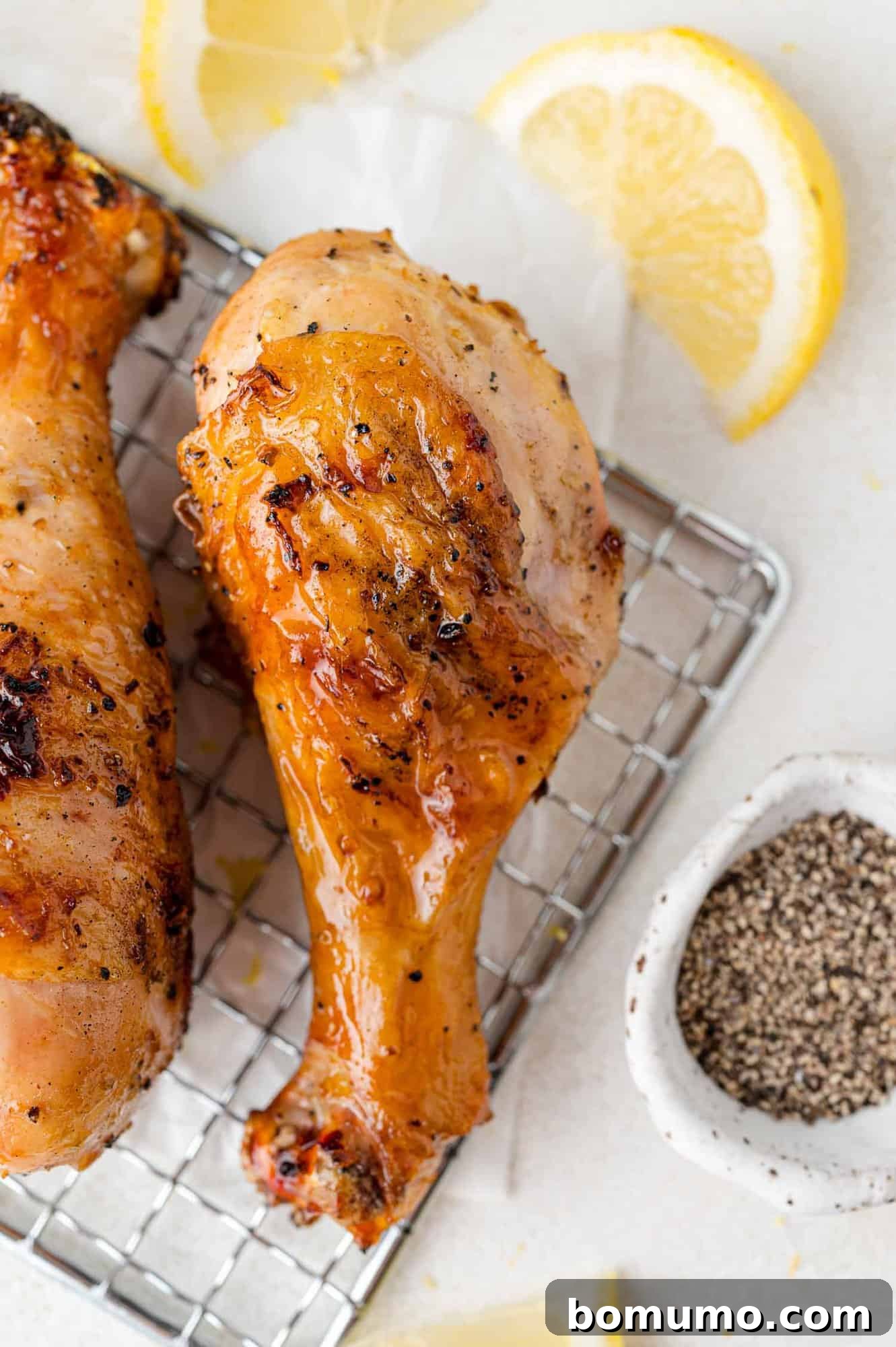 Beautifully marinated chicken drumsticks arranged neatly on a wire rack, ready for grilling or baking.
