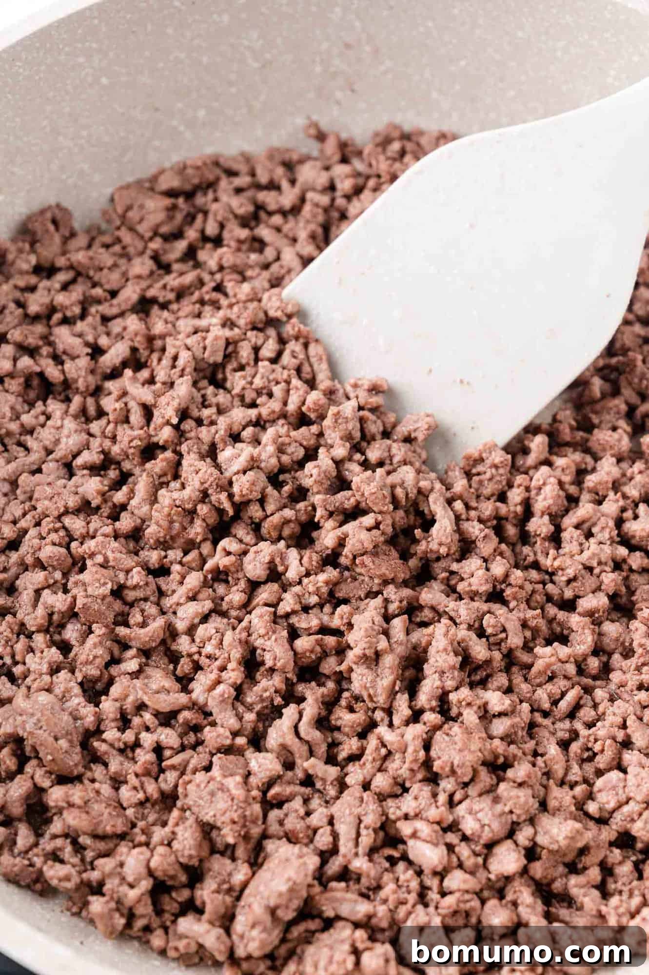 Ground beef being cooked in a frying pan.