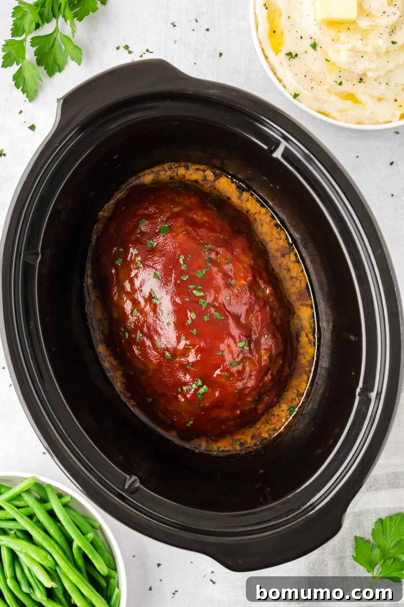 Crockpot meatloaf with a glistening glaze, still warm in the slow cooker.