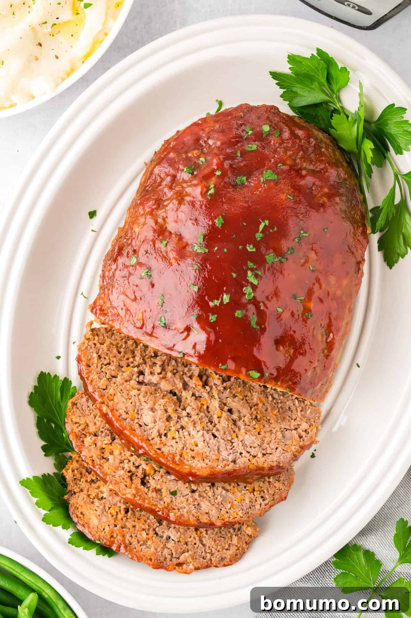 Glazed meatloaf, perfectly sliced on a serving platter, ready to enjoy.