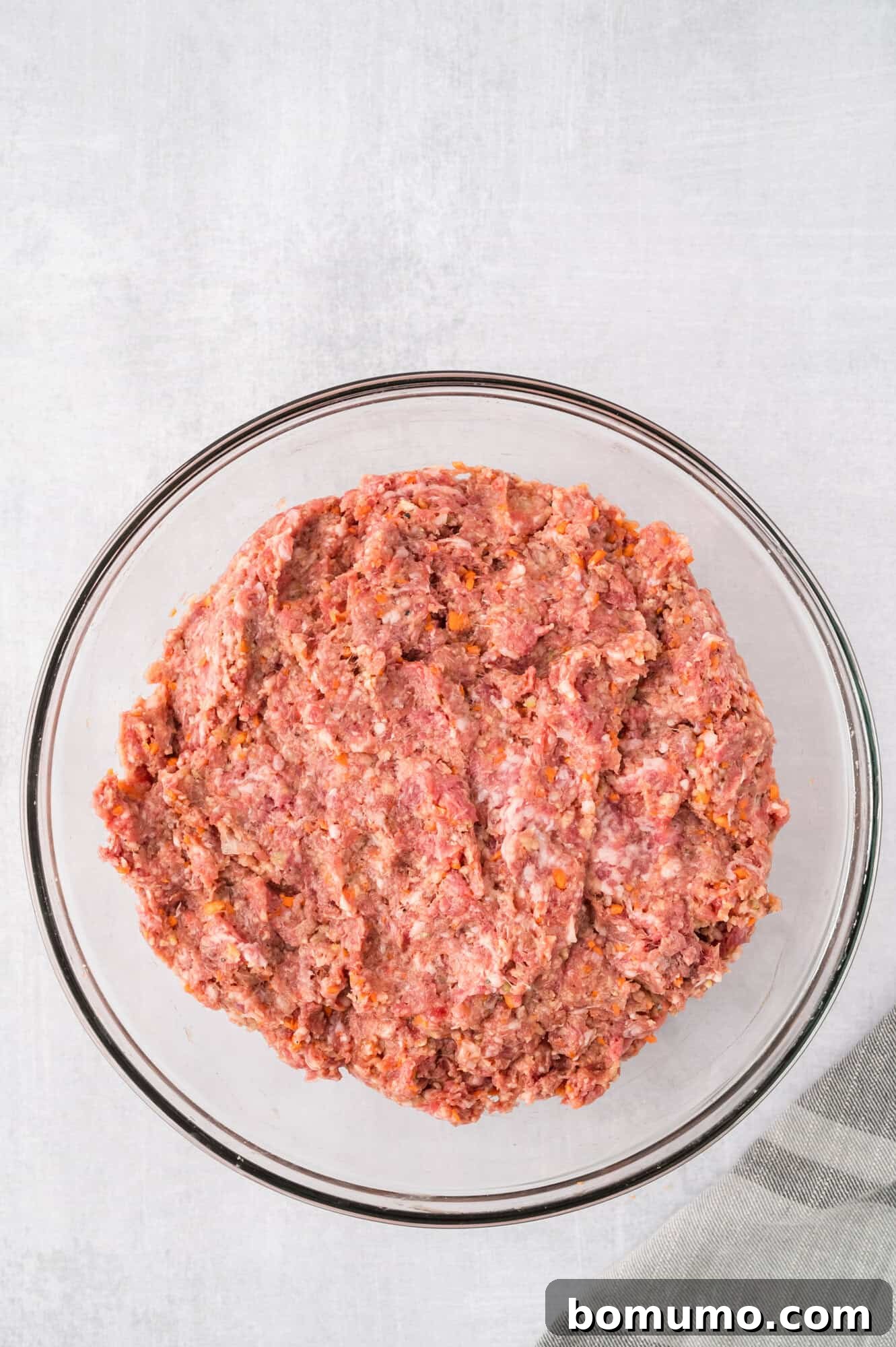 The meatloaf mixture, thoroughly combined but not overmixed, resting in a glass bowl.