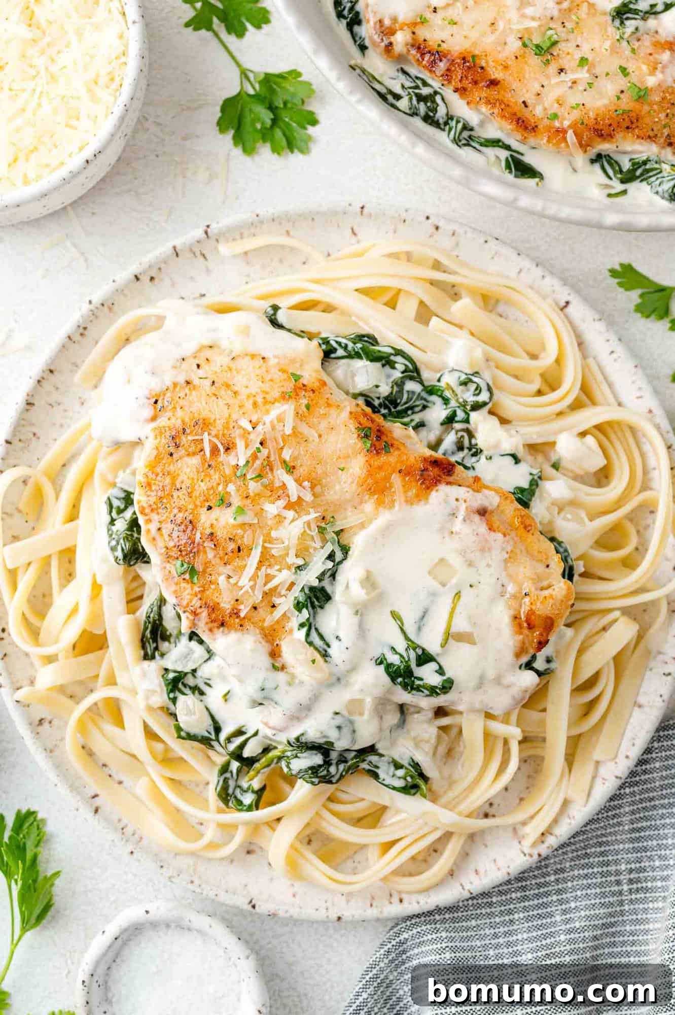 Silken Florentine Chicken 2 A beautifully plated Chicken Florentine dish, served alongside fettuccine, ready to be enjoyed.