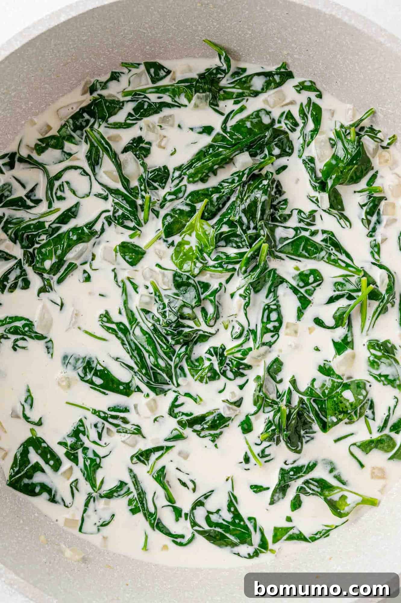Silken Florentine Chicken 12 Rich heavy cream being poured into the skillet, transforming the base into a luxurious sauce.