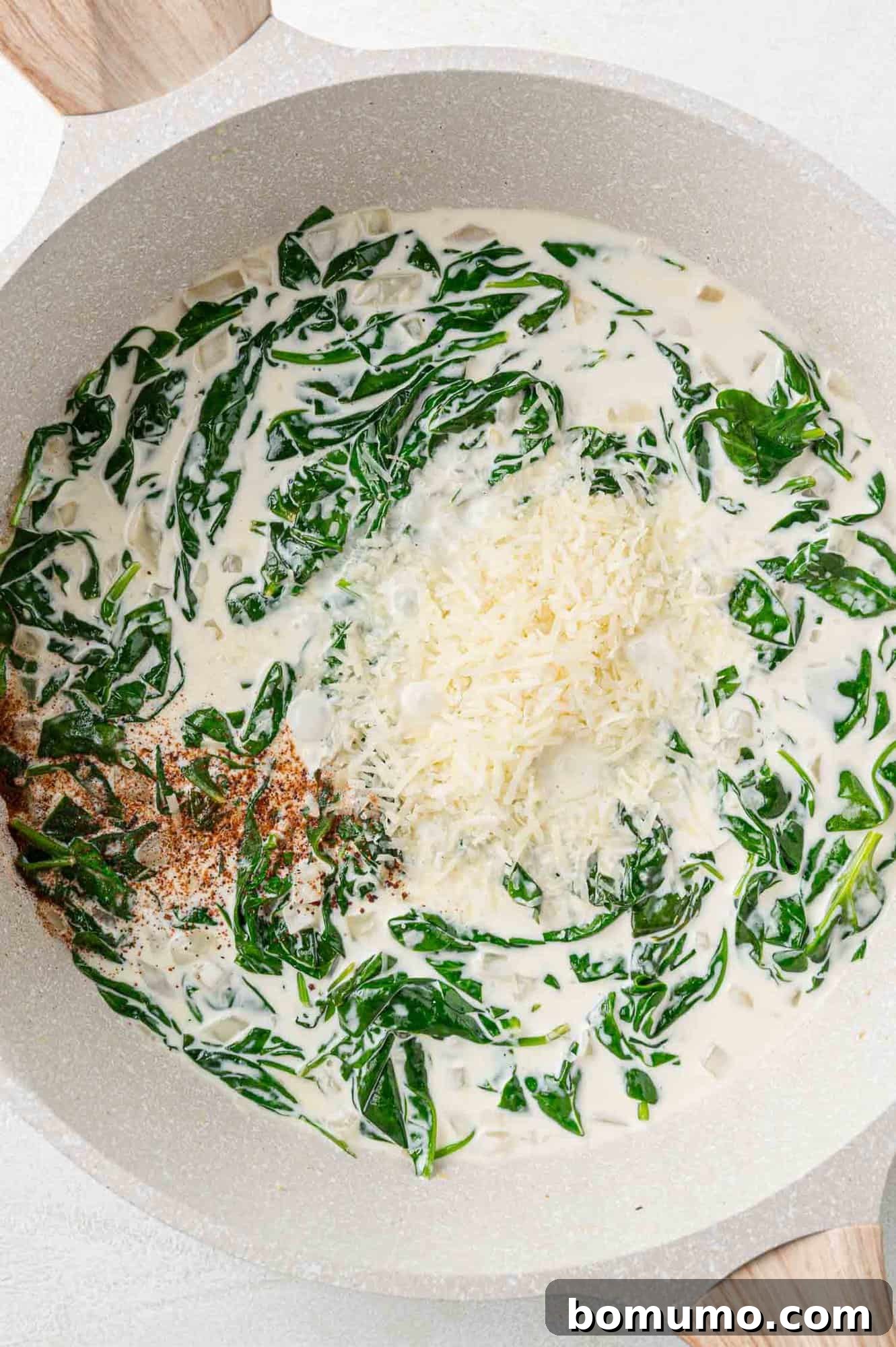 Silken Florentine Chicken 13 Grated Parmesan cheese and a dash of nutmeg being stirred into the simmering cream sauce, enriching its flavor.