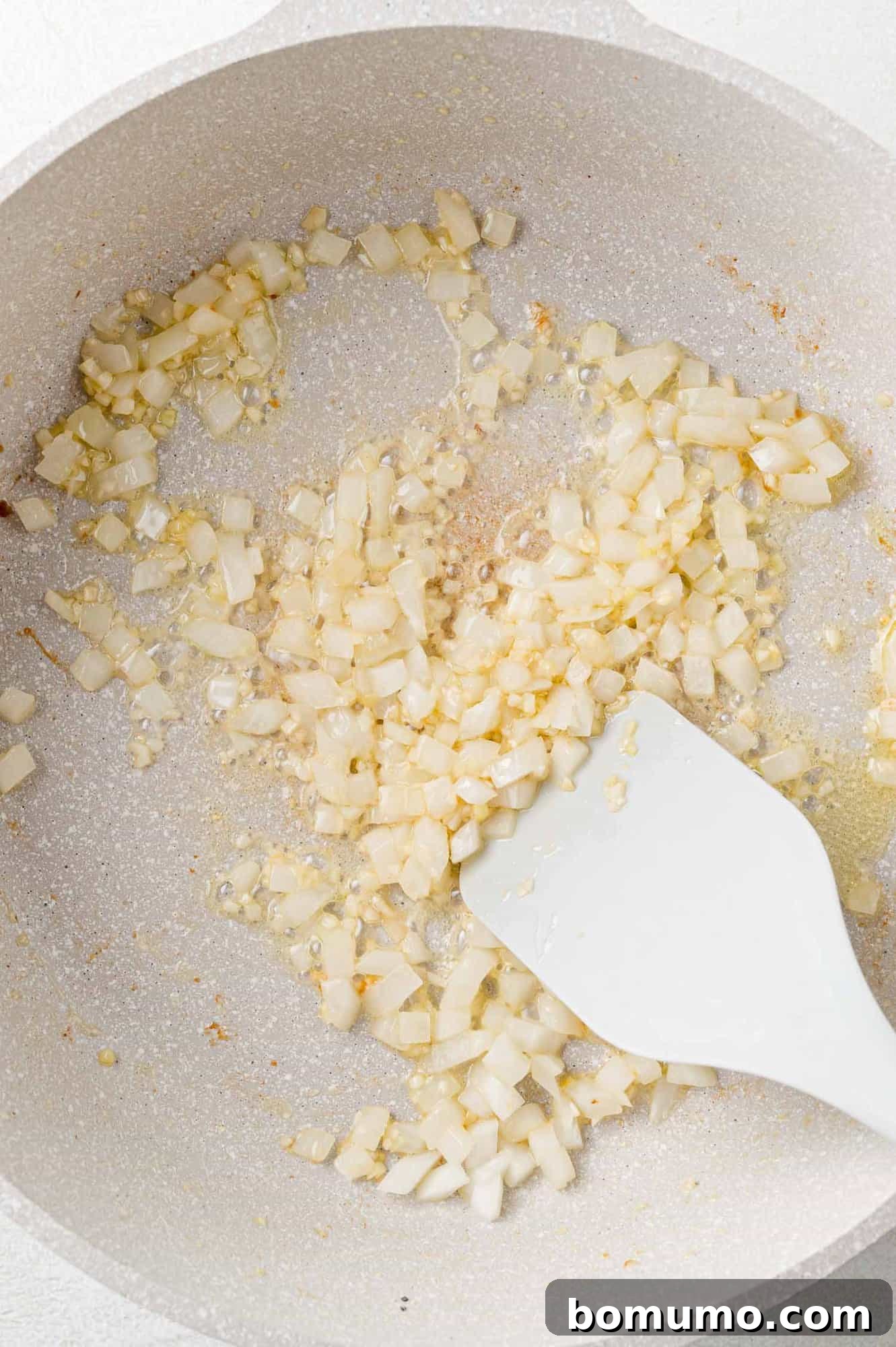 Silken Florentine Chicken 8 Finely chopped onions and minced garlic being gently sautéed in butter within the skillet, releasing their fragrant aromas.