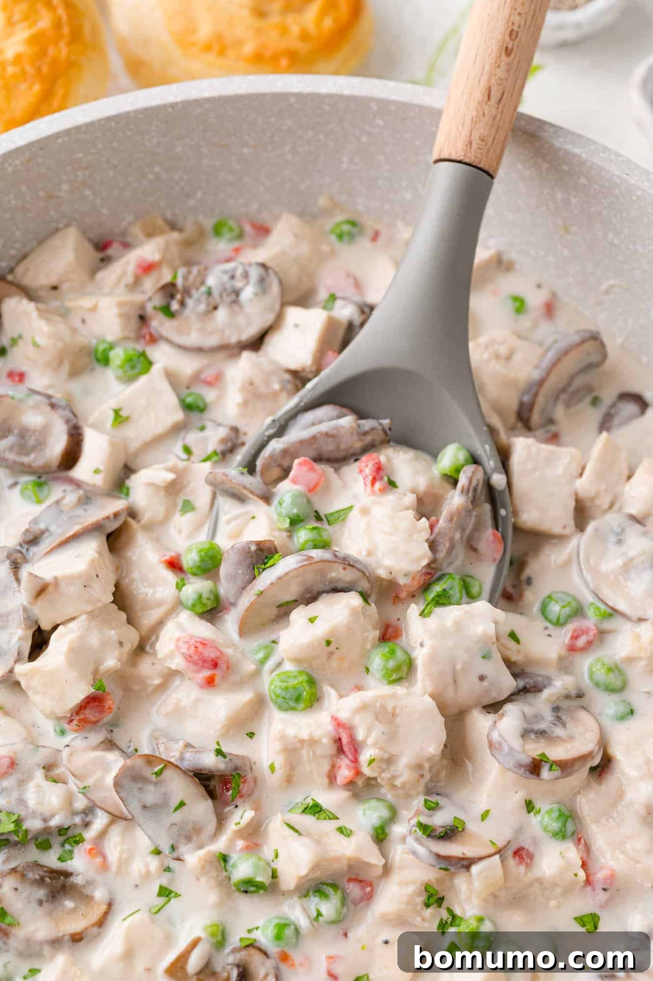 Chicken a la King served in a skillet, featuring tender chicken, mushrooms, and peas in a rich cream sauce.
