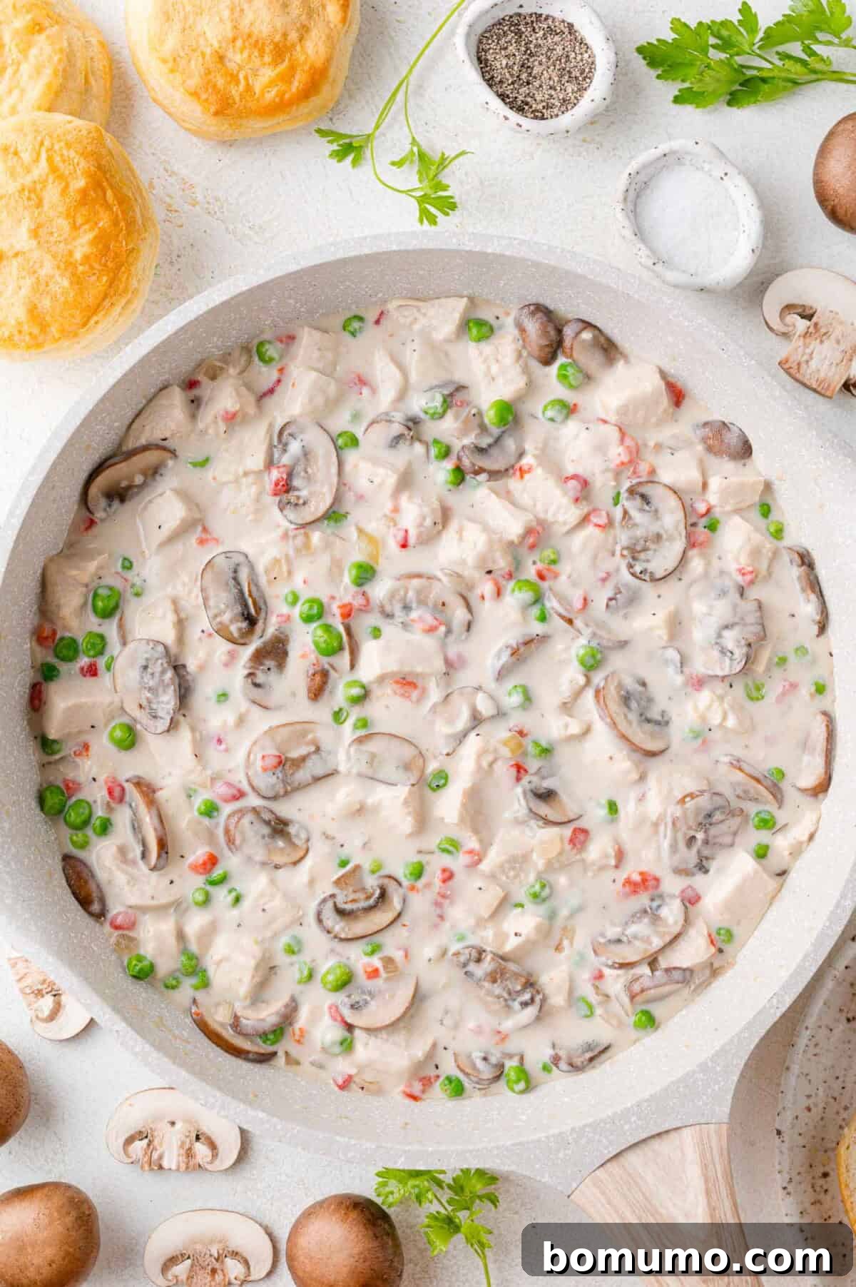 A completed batch of Chicken à la King, rich and creamy, served in a white frying pan, garnished and ready.