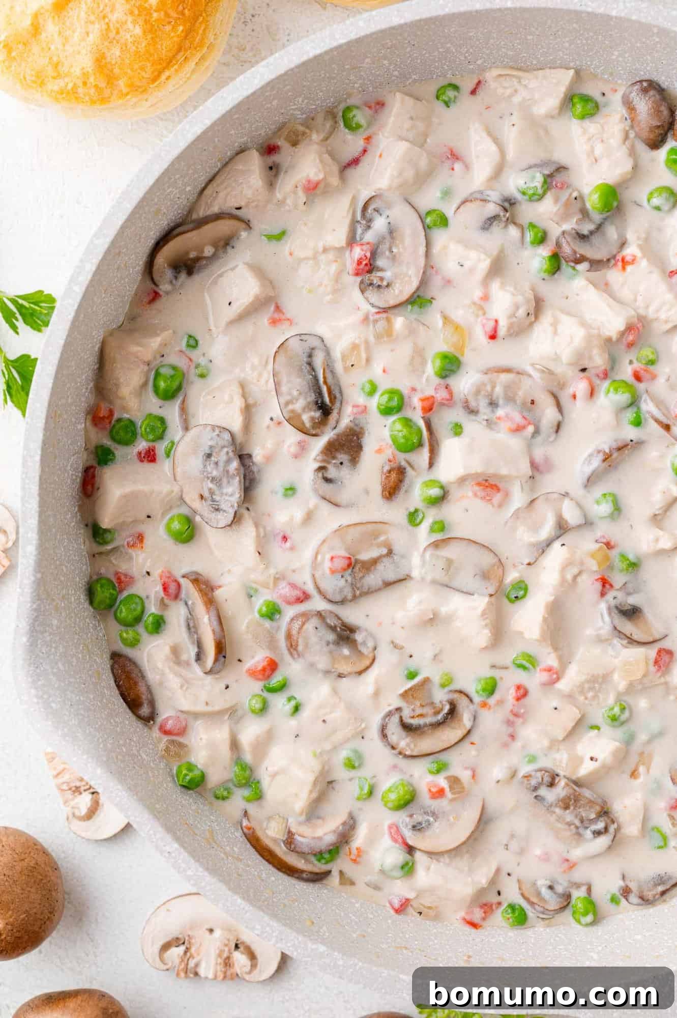 An inviting view of Chicken à la King simmering in a pristine white skillet, showcasing its creamy texture and rich ingredients.