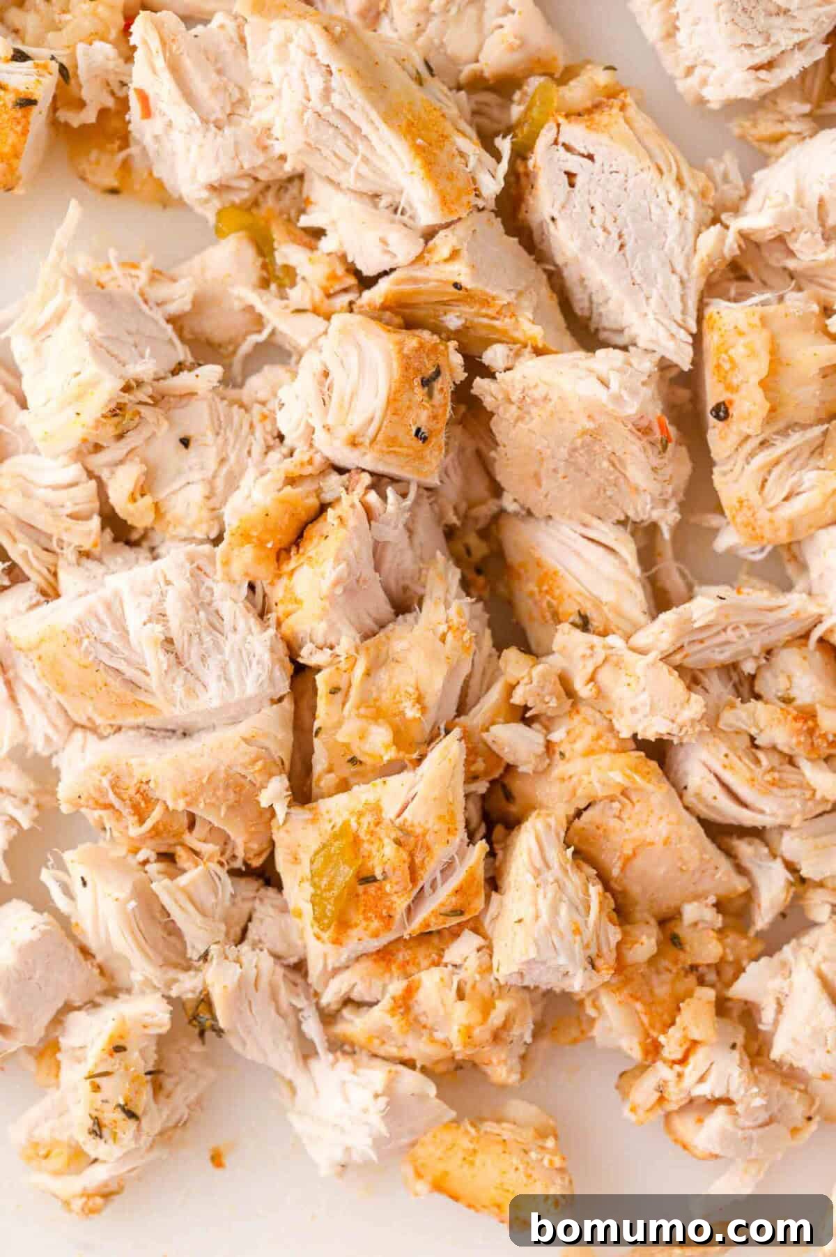 Cooked chicken, diced into bite-sized pieces, ready to be added back into the casserole.