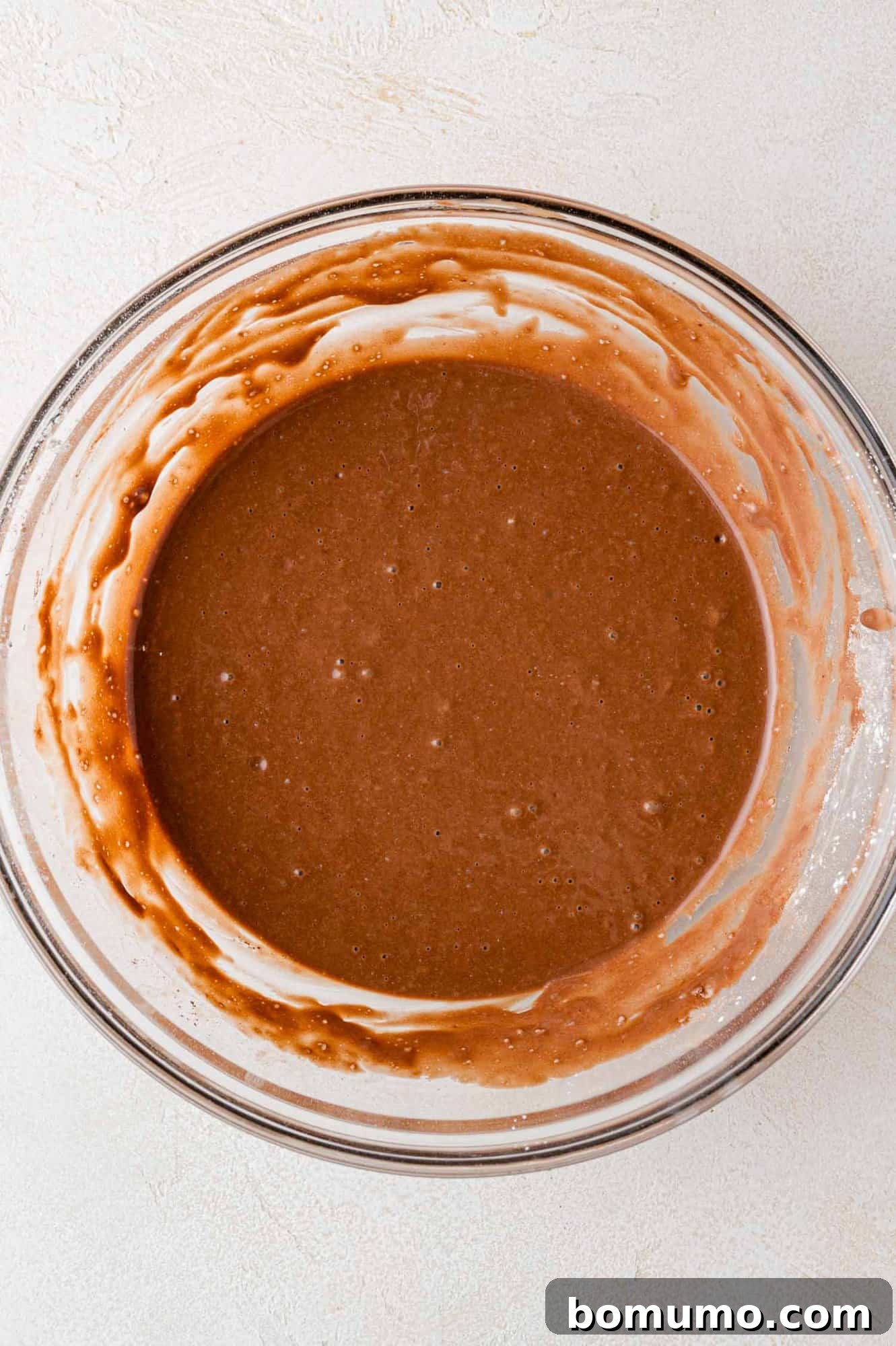 Decadent Chocolate Flapjacks 9 The fully mixed chocolate pancake batter, slightly lumpy, resting in a clear glass bowl.
