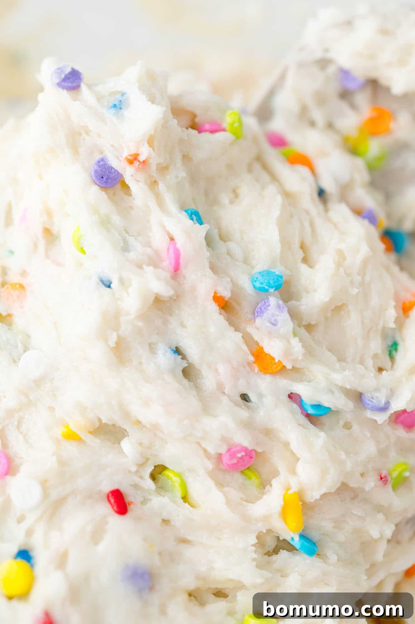 An enticing close-up of a bowl filled with creamy funfetti dip, showcasing its delightful texture and the vibrant confetti sprinkles beautifully mixed throughout. This detail shot emphasizes the fun and festive nature of the dessert.