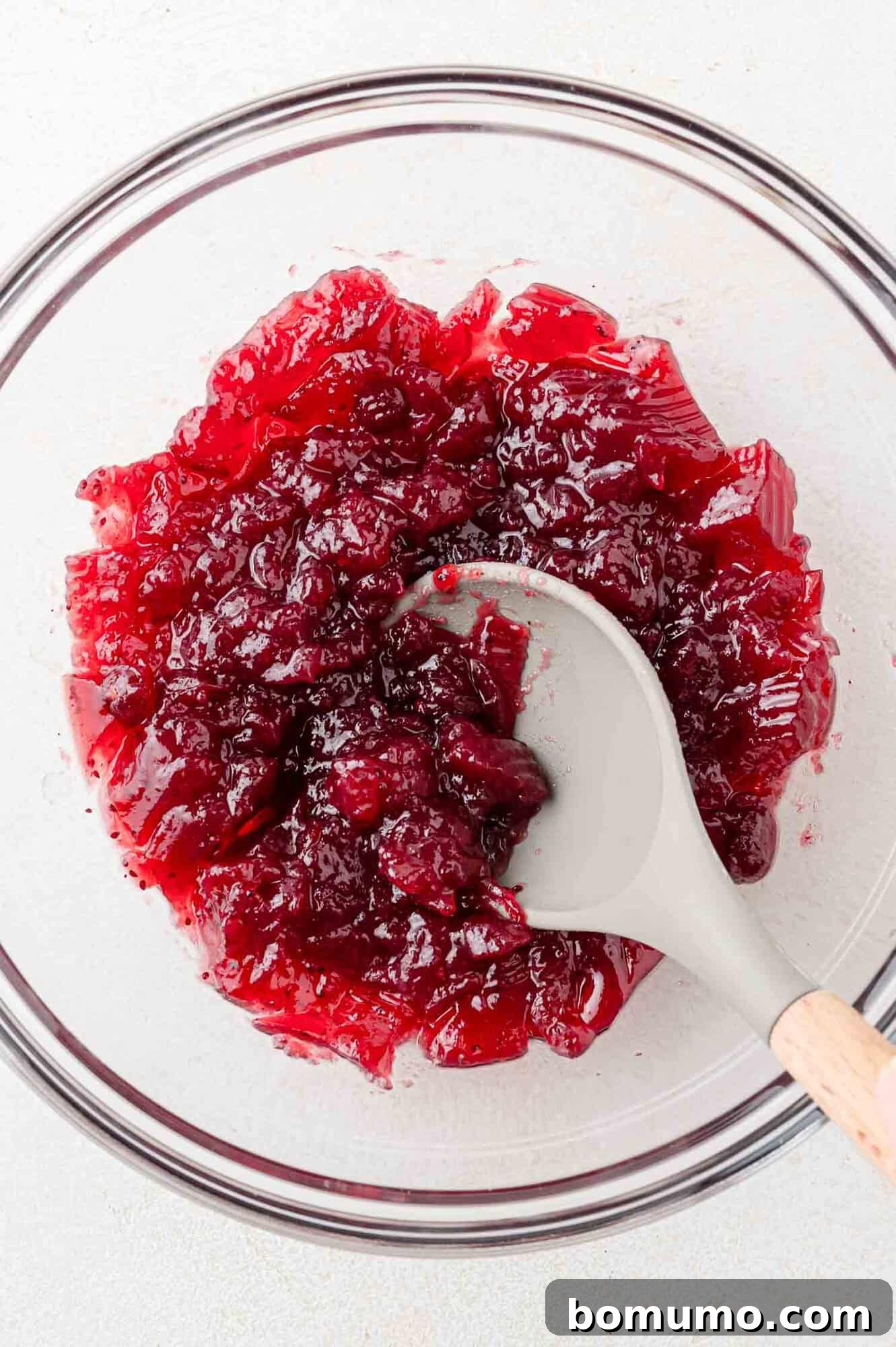 Simple Two Ingredient Cranberry Salsa 6 Cranberry sauce being mashed slightly with a spoon.