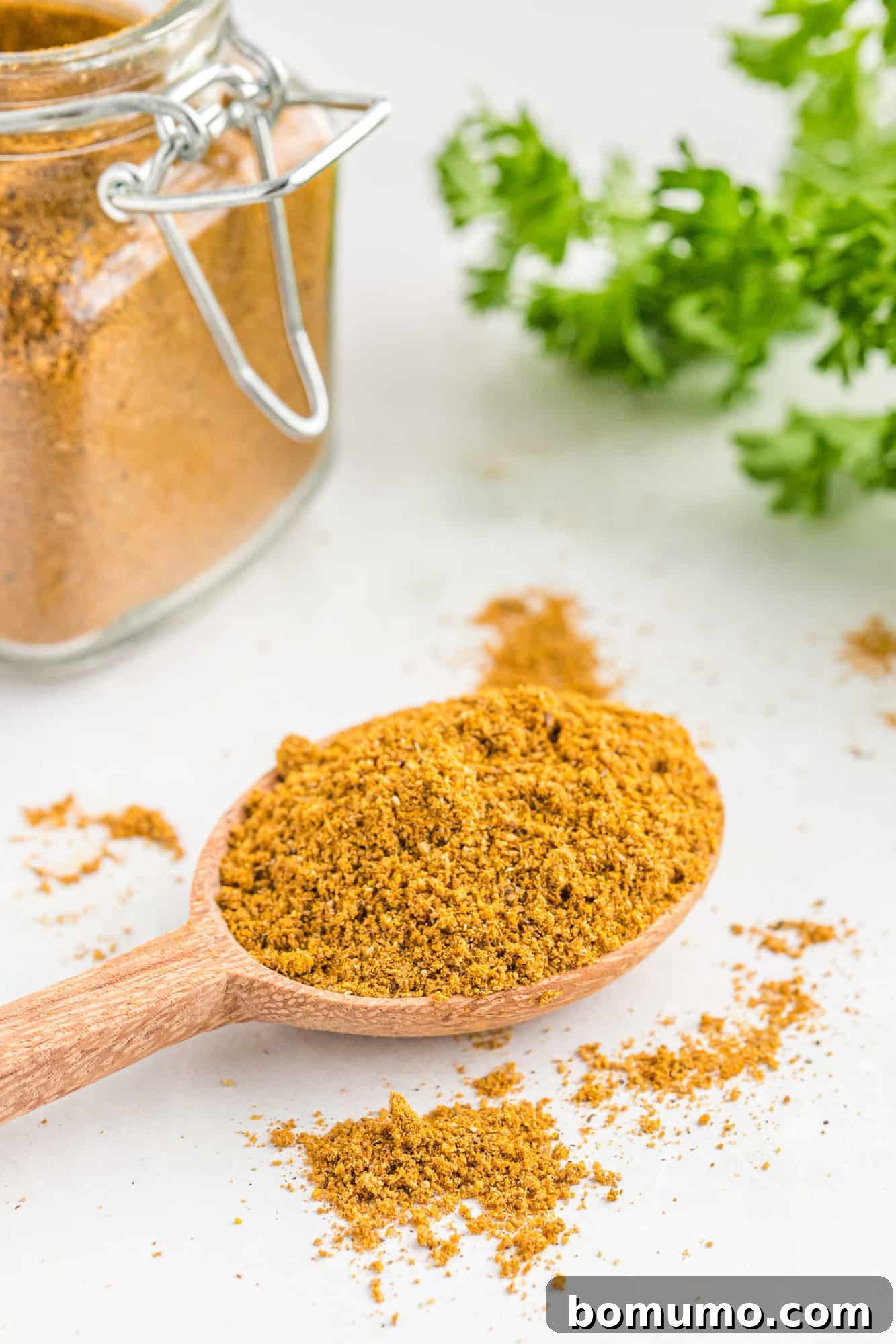 Curry powder on a small wooden spoon, ready to be used in a dish.