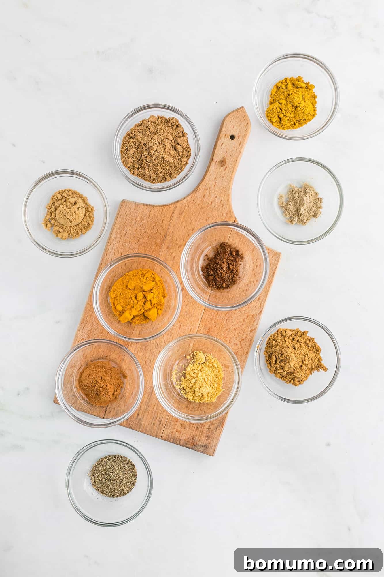 Individual spices in small glass bowls, meticulously arranged.