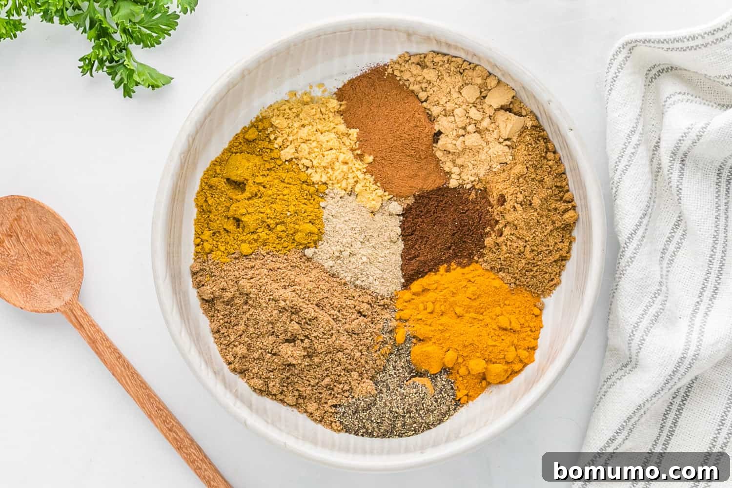 Unmixed spices laid out on a clean surface, awaiting combination.