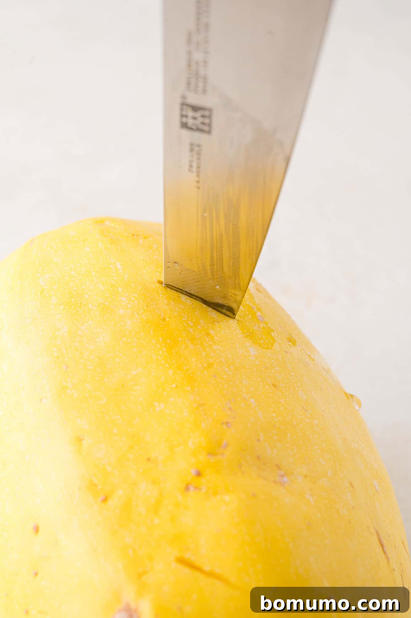 Easy Instant Pot Spaghetti Squash 5 Spaghetti squash being punctured with a knife.