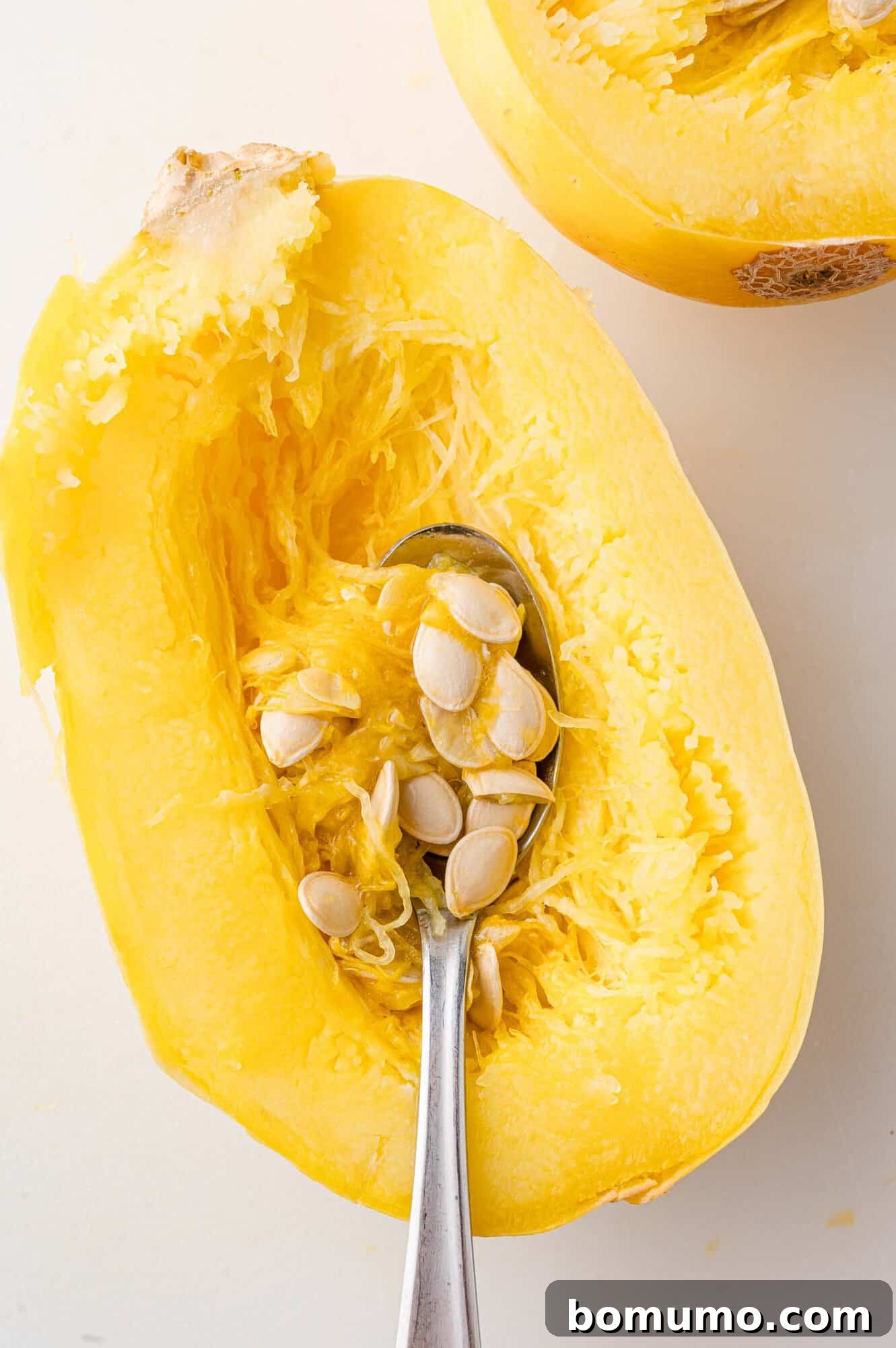 Easy Instant Pot Spaghetti Squash 8 Seeds being removed from cooked spaghetti squash.