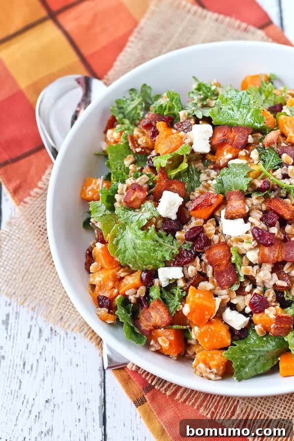 Overhead shot of a round white bowl brimming with a vibrant farro salad, artfully placed on a rustic burlap and plaid cloth, adorned with rich fall colors.