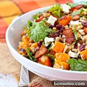 Partial front view of a vibrant farro salad in a shallow white bowl, showcasing its delicious ingredients.