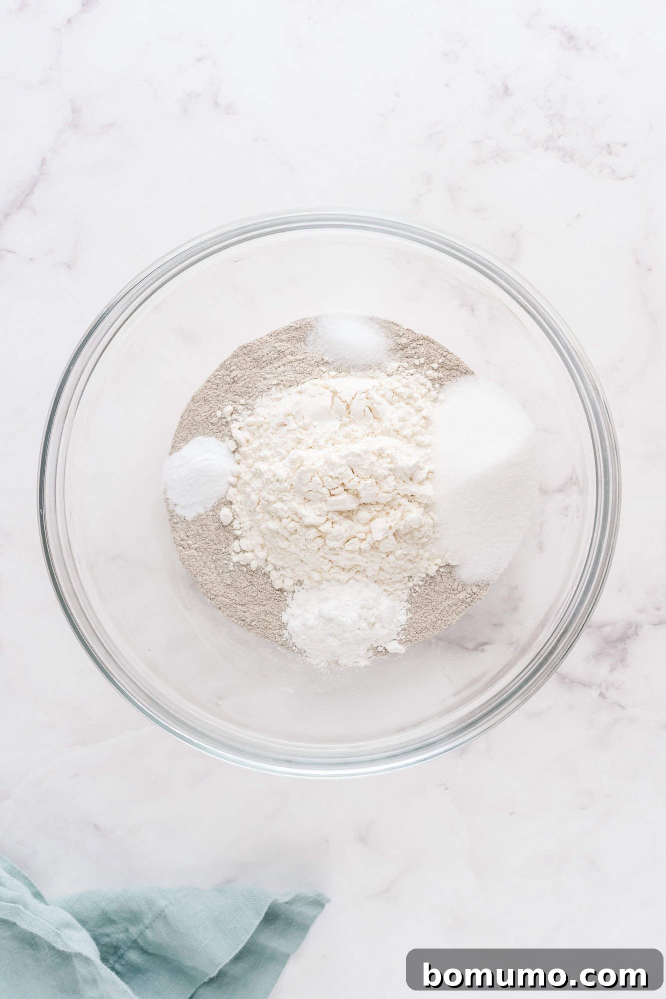 All dry ingredients gathered in a single large glass bowl, prior to mixing.