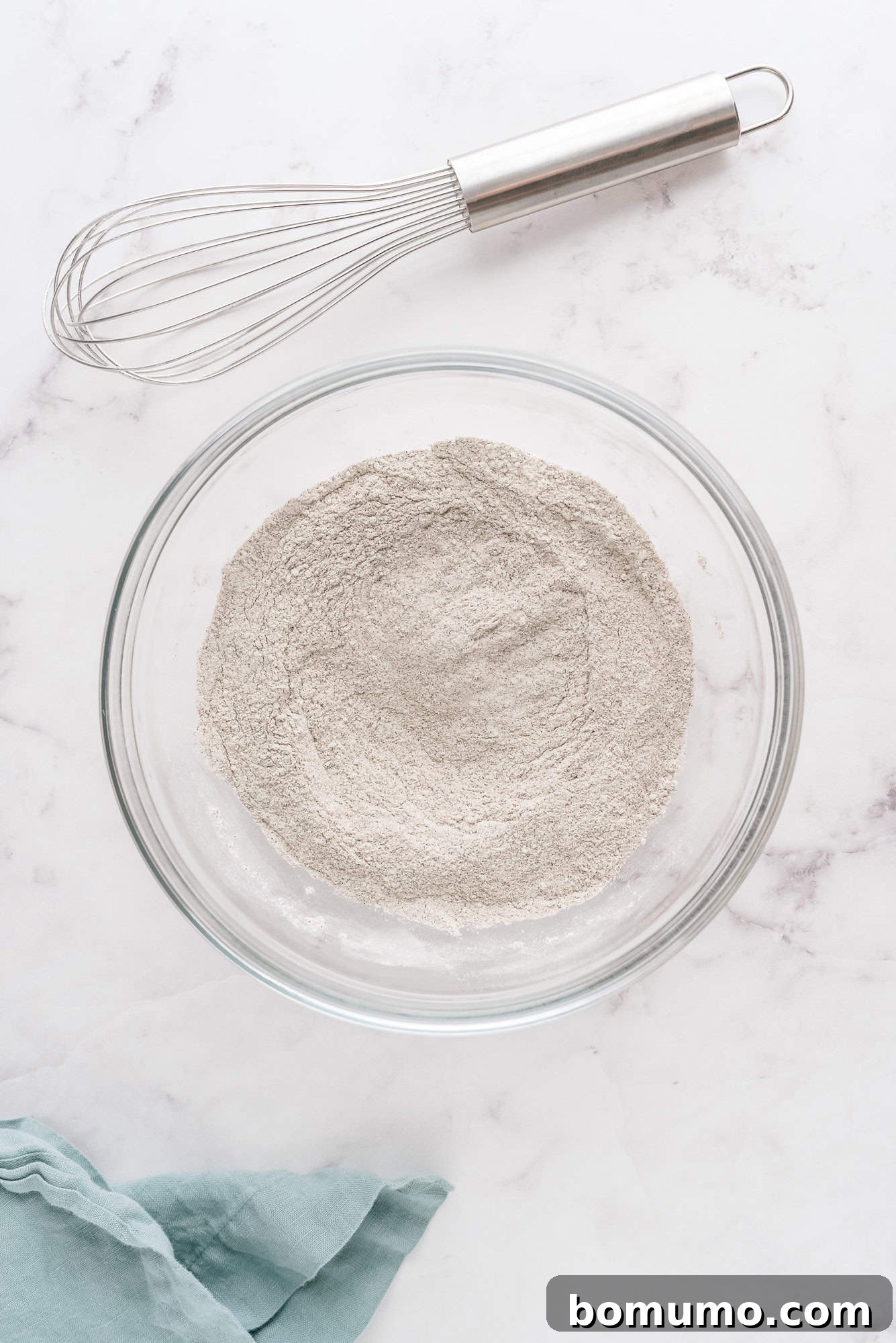 The dry ingredients, now perfectly combined and whisked together in a bowl, forming a uniform mixture.