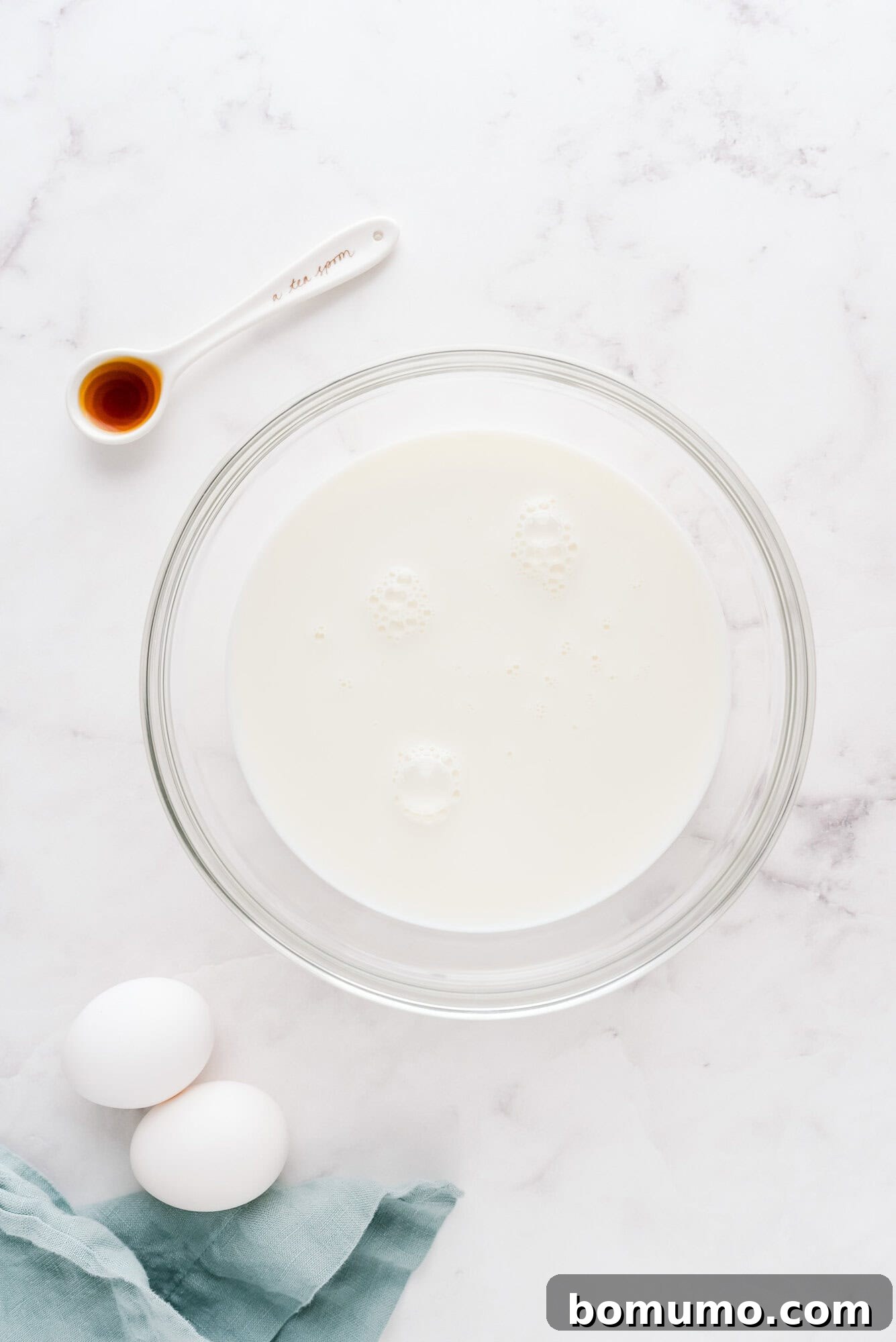 Individual wet ingredients, such as milk, eggs, and vanilla, presented separately in clear bowls.