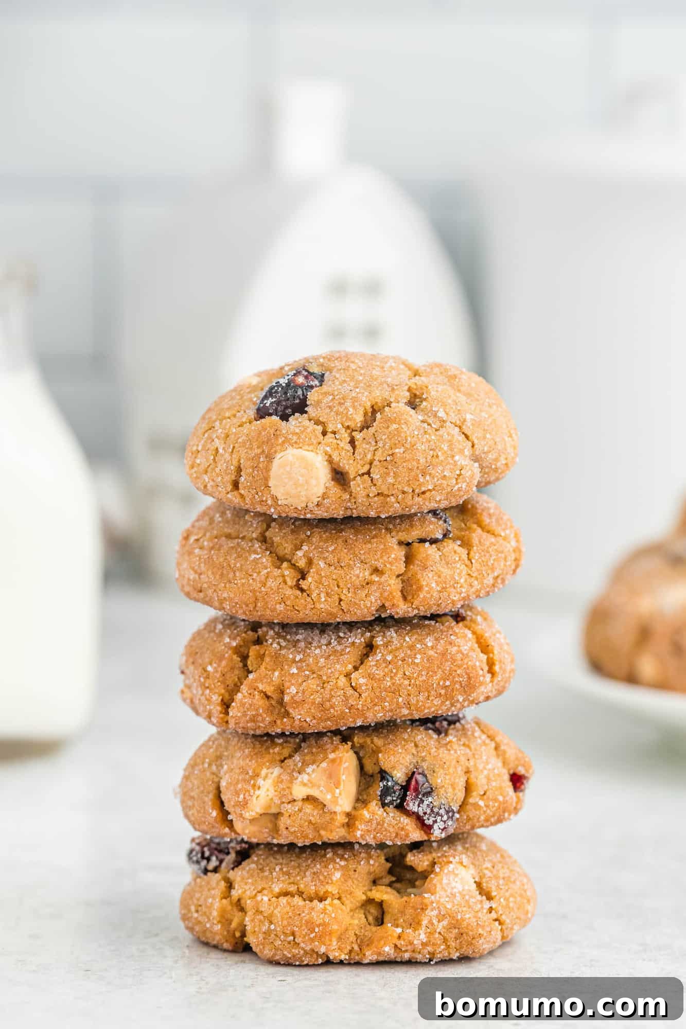 Tall stack of thick sugar rolled ginger cookies, illustrating their tempting golden-brown hue and classic cracked surface.