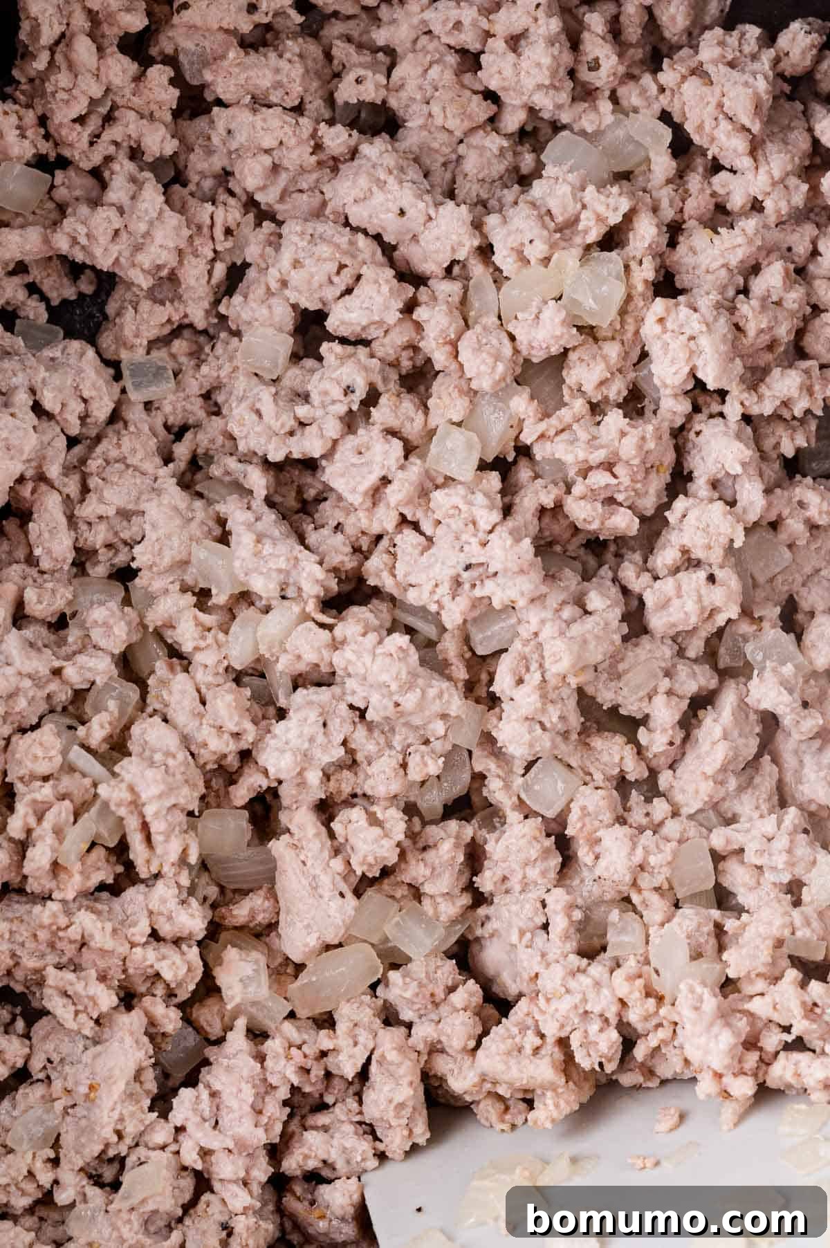 Deconstructed Cabbage Roll Soup 5 A close-up view of perfectly browned ground meat mixed with finely diced onions, sautéing together in a large pot, forming a fragrant base for the soup.