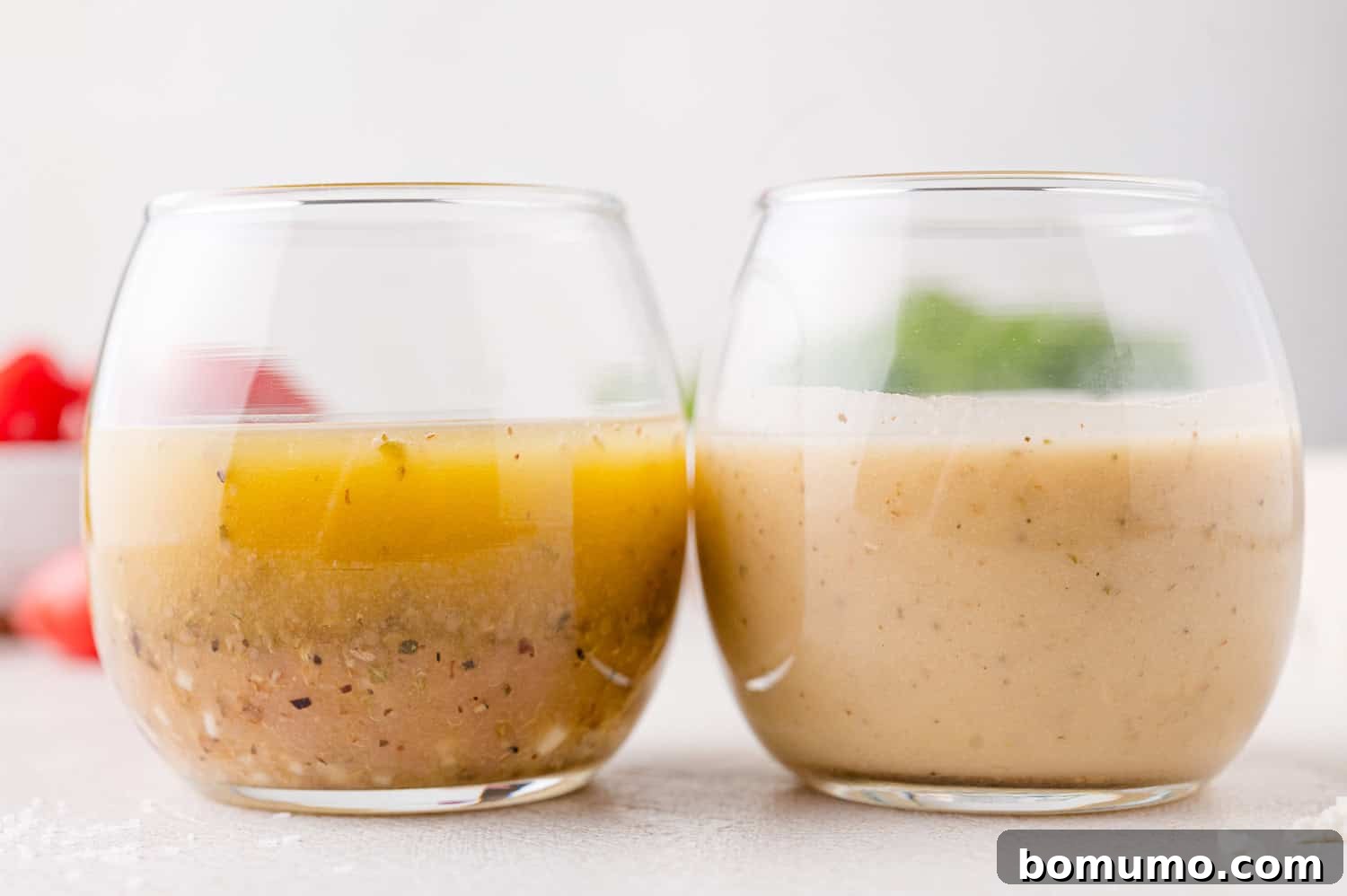 Two round glasses filled with vinaigrette dressing; the left glass shows separation, while the right glass appears blended. 