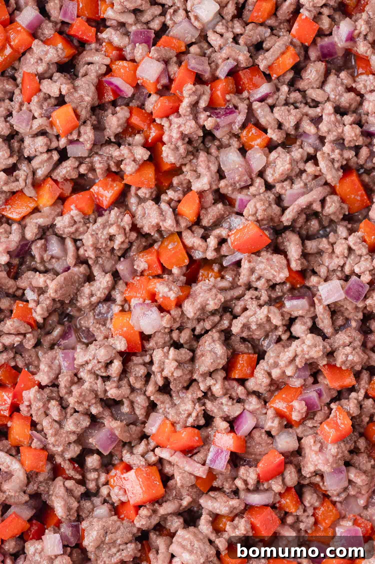 Effortless Sheet Pan Quesadillas 7 Cooked ground beef mixed with diced red bell peppers and onions, ready for the next step of the quesadilla filling.