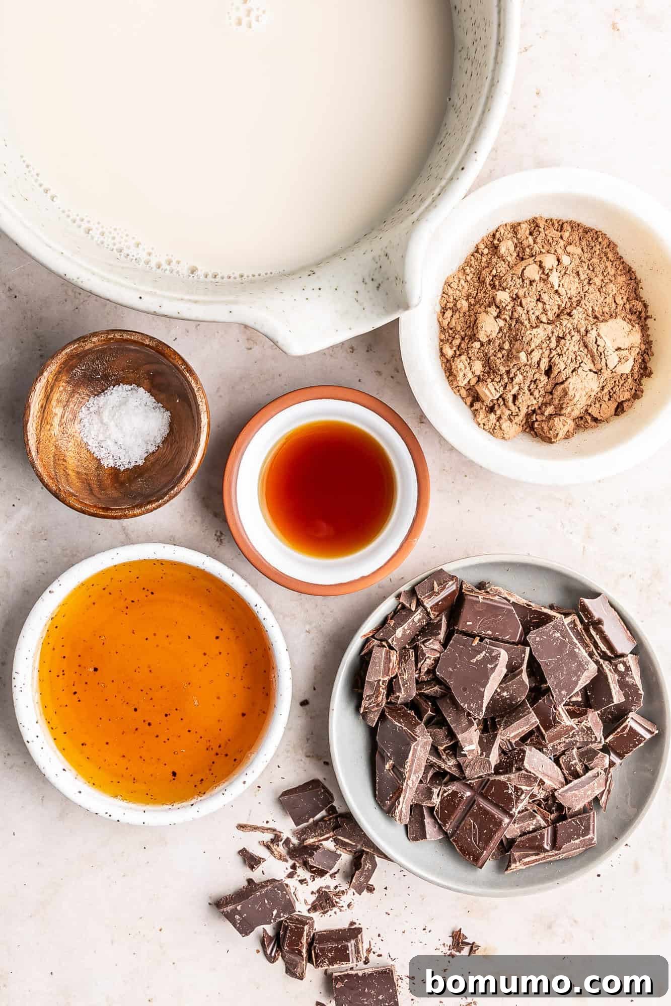 Overhead view of all fresh ingredients laid out on a table, ready to be combined for the oat milk hot chocolate recipe, emphasizing simplicity.