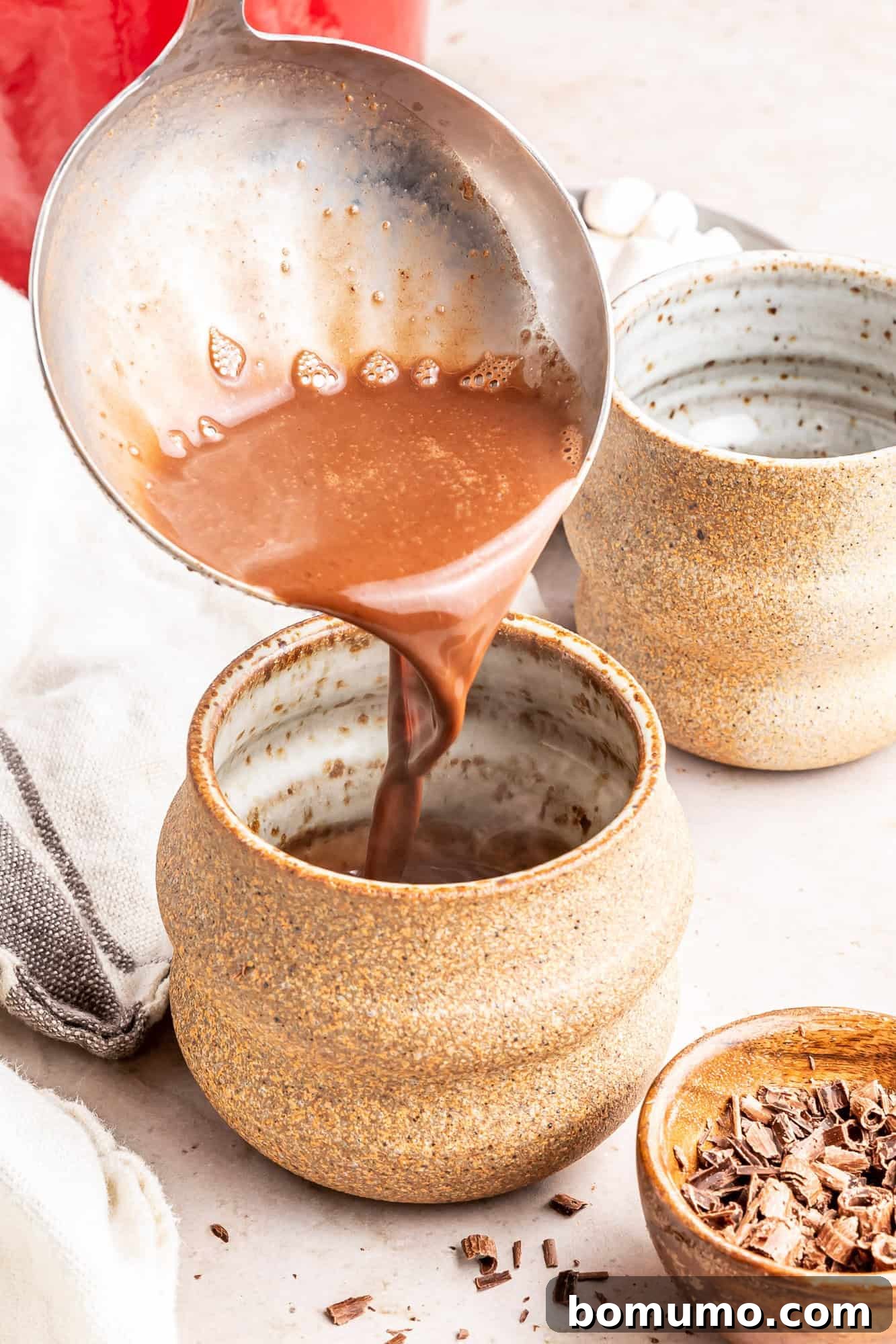 Finished oat milk hot chocolate being poured into an elegant mug, ready to be enjoyed.