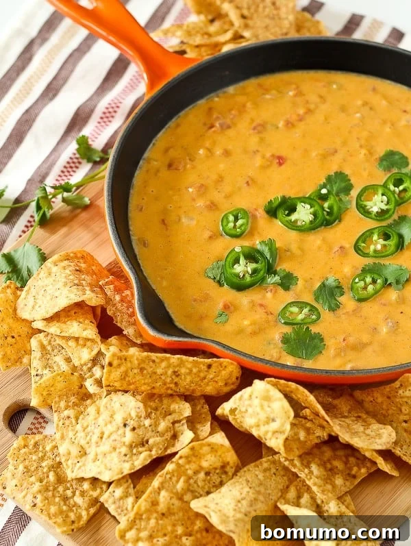 Healthy queso dip in an orange frying pan.