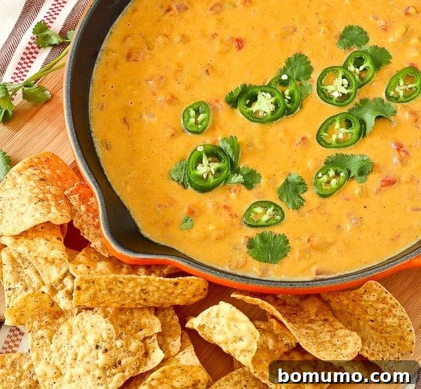 Orange queso dip topped with jalapeño slices. 