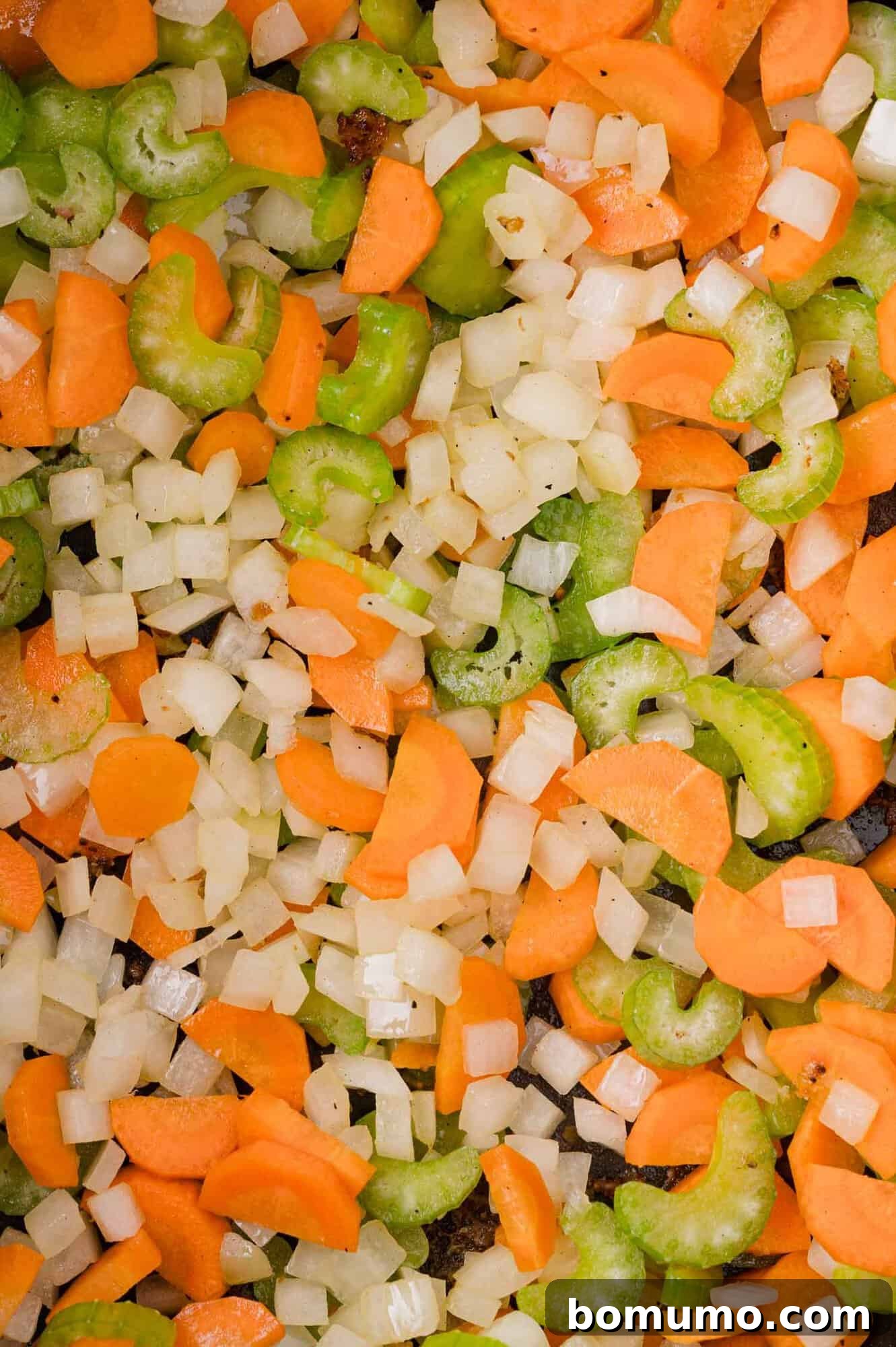 Diced carrots, celery, and onions are mixed together, creating a colorful vegetable medley.