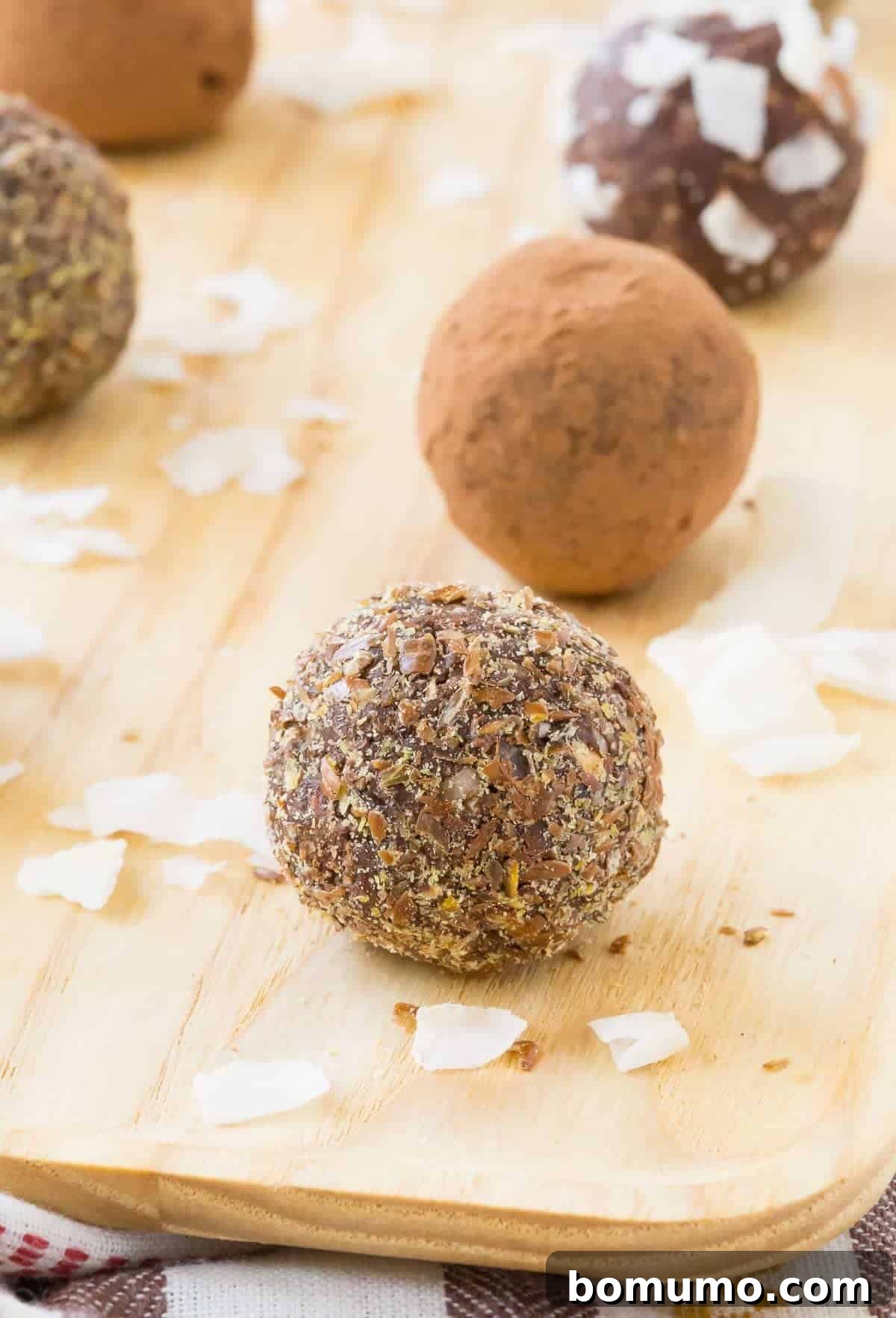 Delicious nut-free chocolate coconut energy balls arranged on a rustic wooden surface, perfect for a healthy snack.