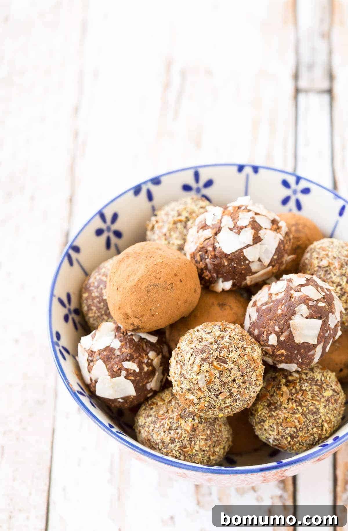 Ready-to-eat nut-free chocolate energy balls in an elegant blue and white bowl, showcased as a delicious and healthy snack.