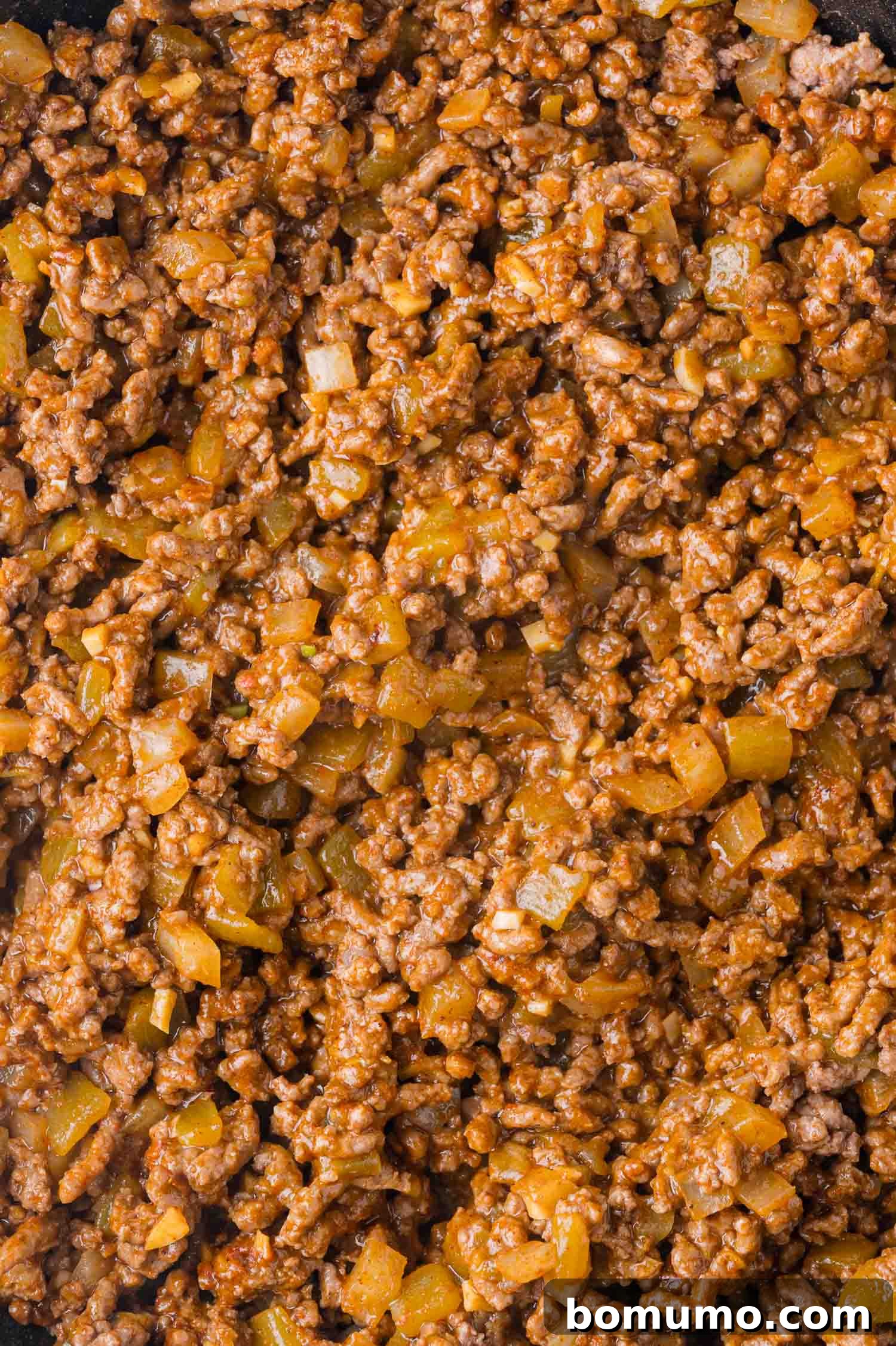 Hearty Beef Enchilada Bake 7 Close-up of cooked ground meat mixed with chopped onions and spices.