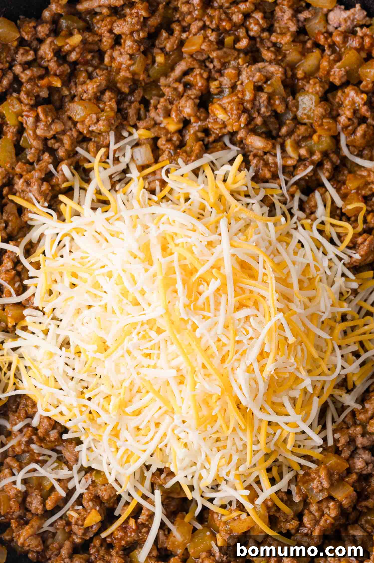 Hearty Beef Enchilada Bake 8 Ground meat mixture with chopped vegetables, topped with a blend of shredded cheddar and mozzarella cheese.