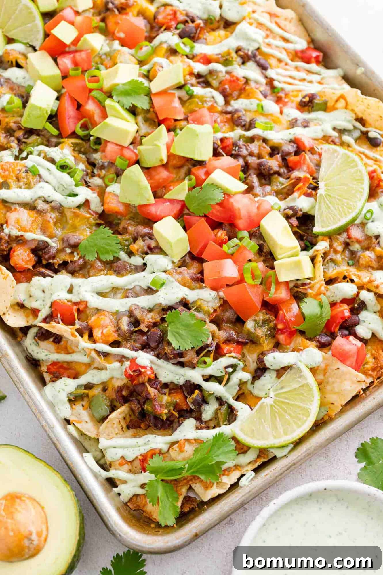 Nachos and toppings on a sheet pan.