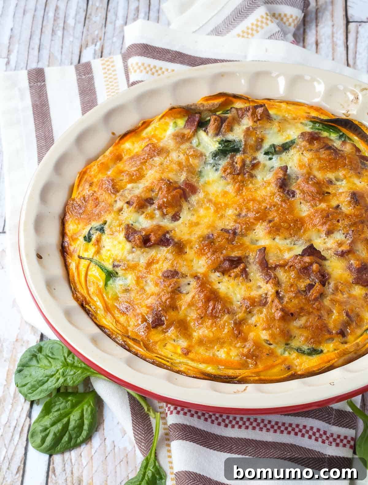 Close up overhead shot of a perfectly baked Bacon Cheddar Quiche with Sweet Potato Crust in a pie dish, ready to be served.