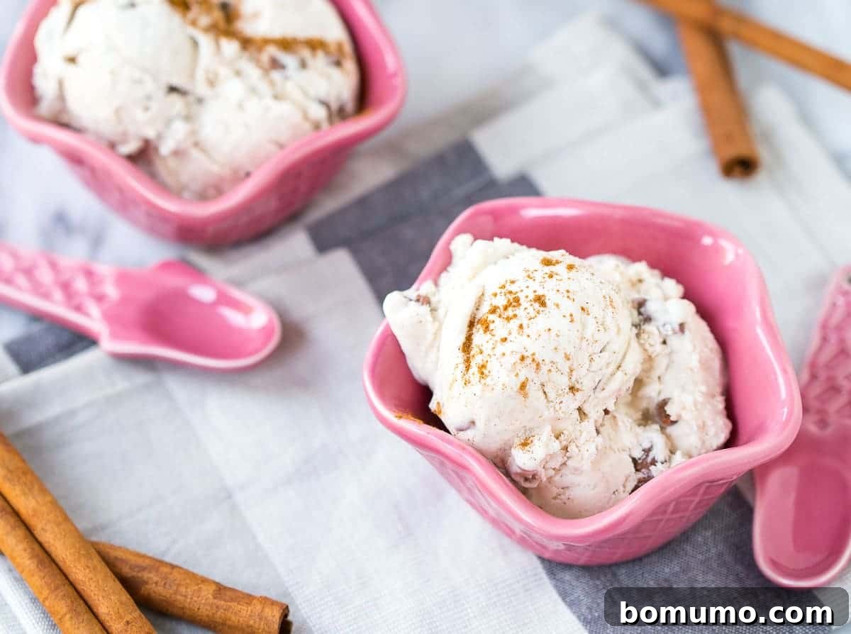 Pink decorative bowls containing ice cream, along with pink cone shaped spoons.