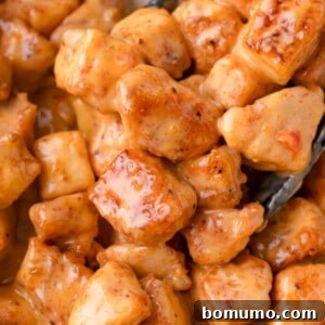 Close-up of golden-brown, bite-sized chicken pieces generously coated in luscious Bang Bang sauce.