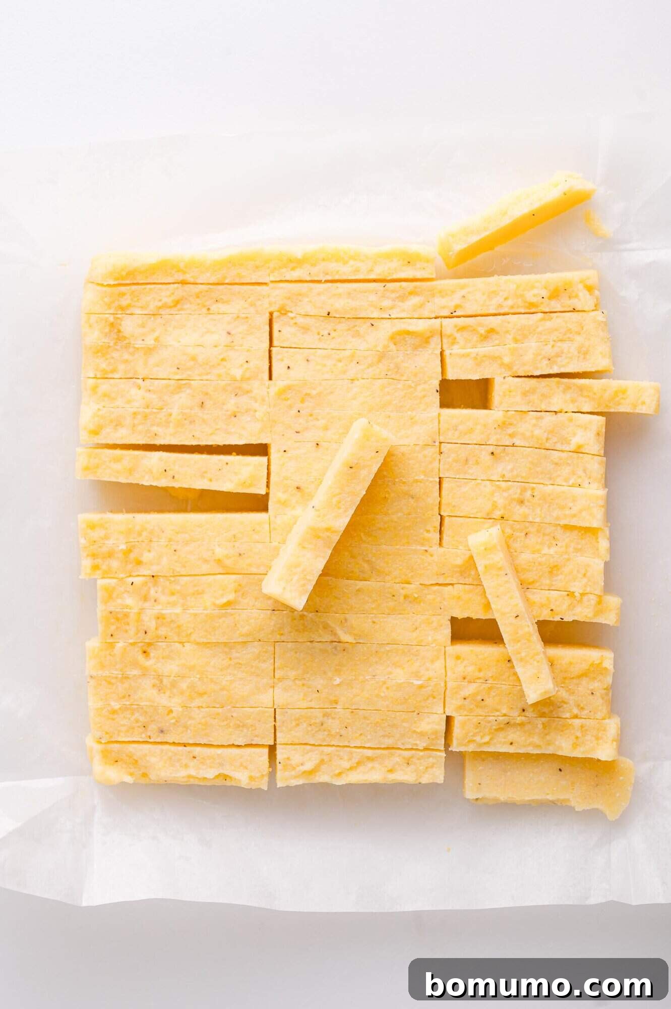 Cut polenta fries on parchment paper.