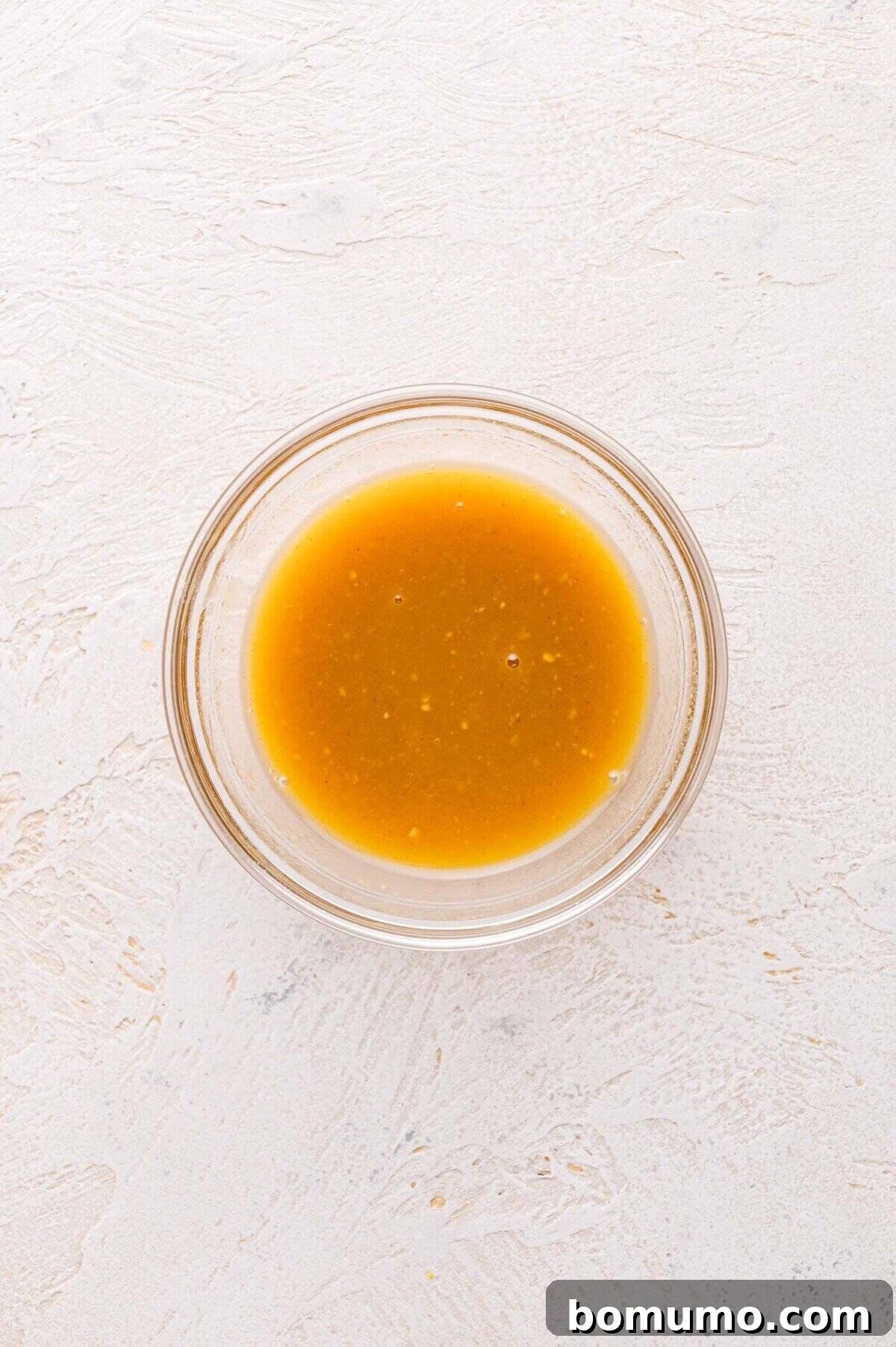 A small glass bowl containing maple mustard mixture.
